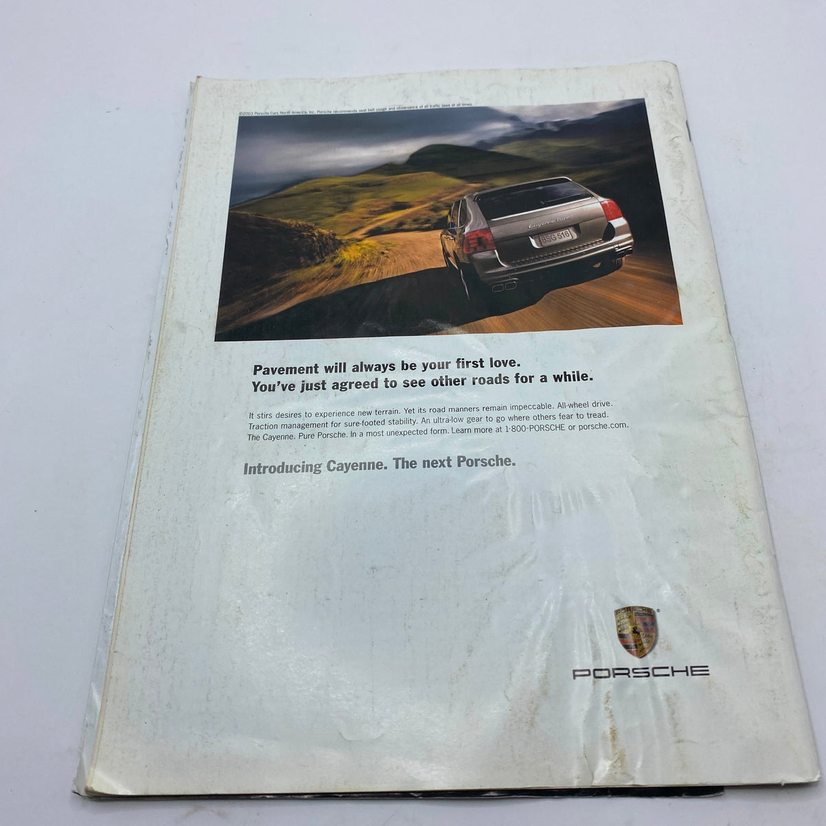 Back cover of Tennis Magazine July 2003, featuring a Porsche advertisement highlighting the Cayenne model and beautiful scenic drive.