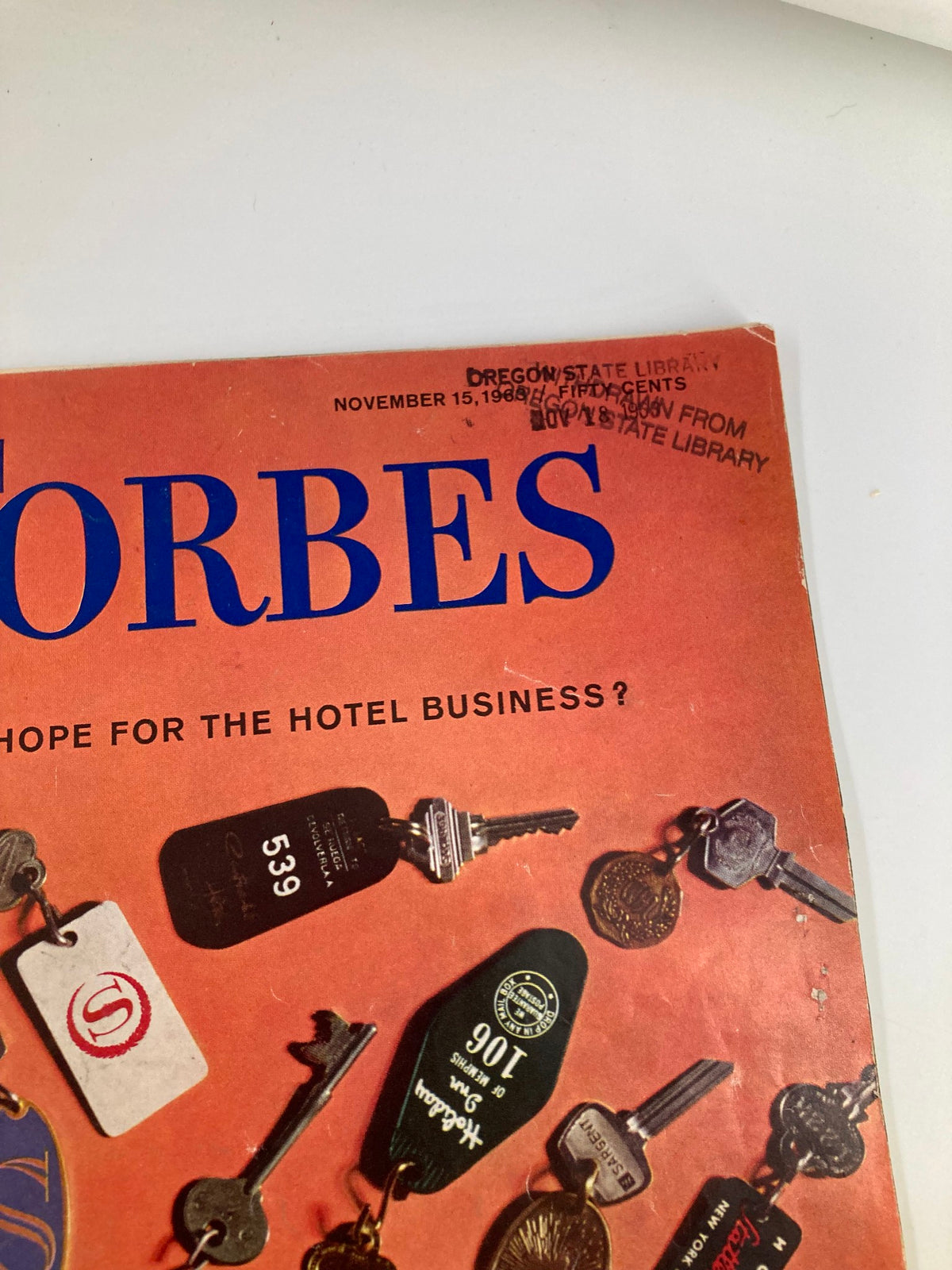 Close-up of the cover of VTG Forbes Magazine November 15, 1963 showcasing the title 'What Hope For The Hotel Business?' and detailing the condition with library stamps.