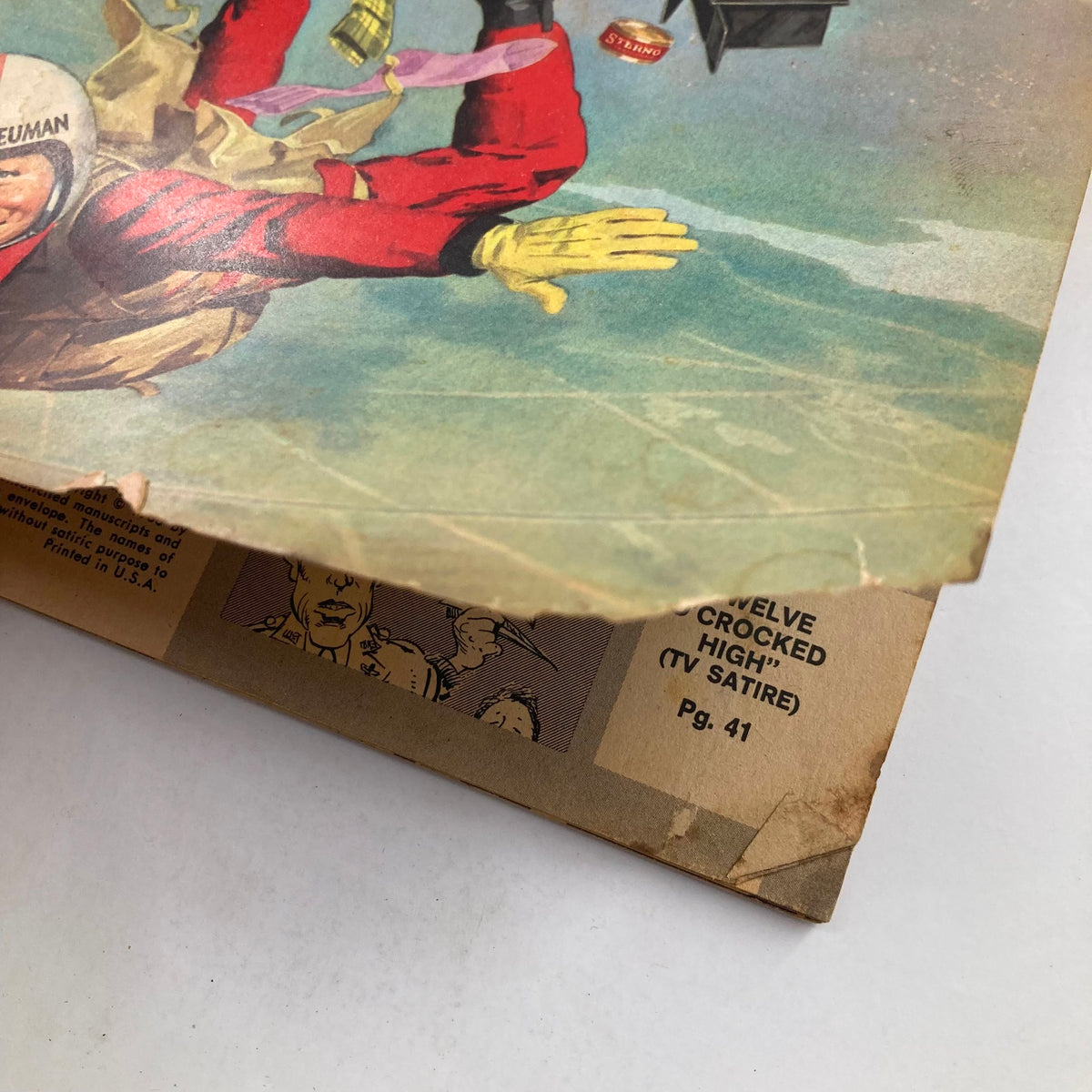 Close-up view of Mad Magazine October 1966 No. 106, showcasing the detailed artwork of the cover with signs of wear including a tear, reflecting its vintage character and historical significance.