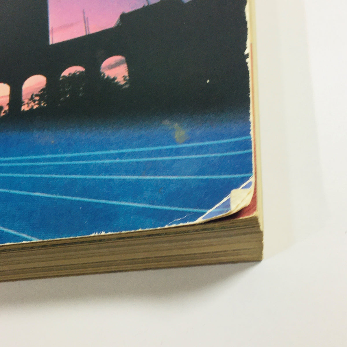 Close-up view of the edges of the Official Olympic Souvenir Program 1984 - Games of XXIIIrd Olympiad Los Angeles, showing minor wear and tear.