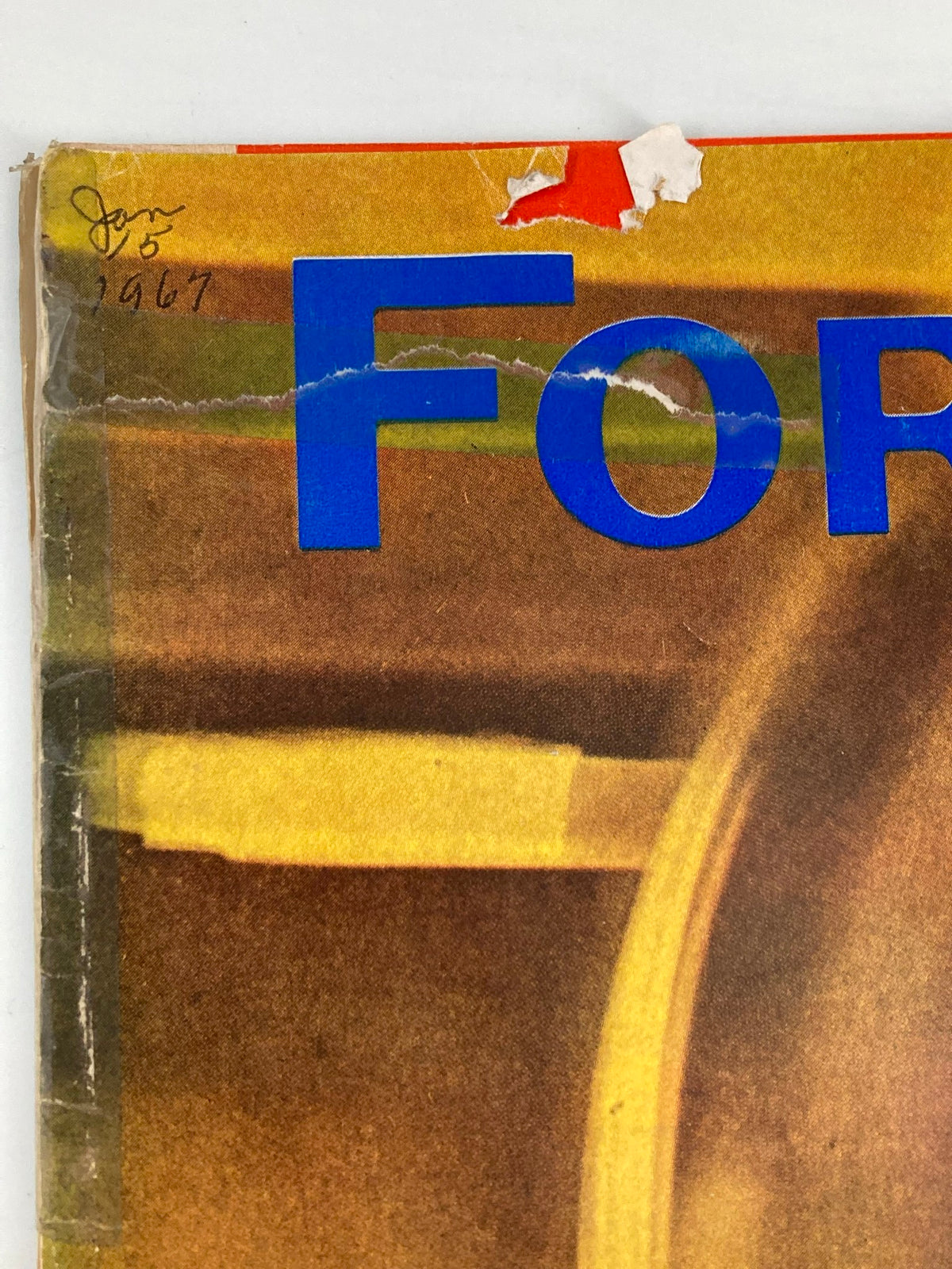 Detailed view of the top section of the vintage Forbes Magazine cover dated January 15, 1967, showcasing the title 'Steel Wheels on Steel Rails' and wear from age.