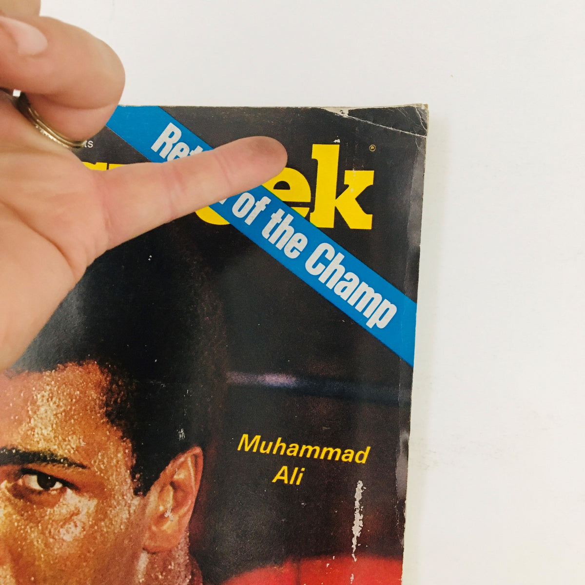 Close-up of the Newsweek Magazine cover from November 9, 1970, showcasing Muhammad Ali and the title 'Return of the Champ', with visible hand gesture pointing at the cover.