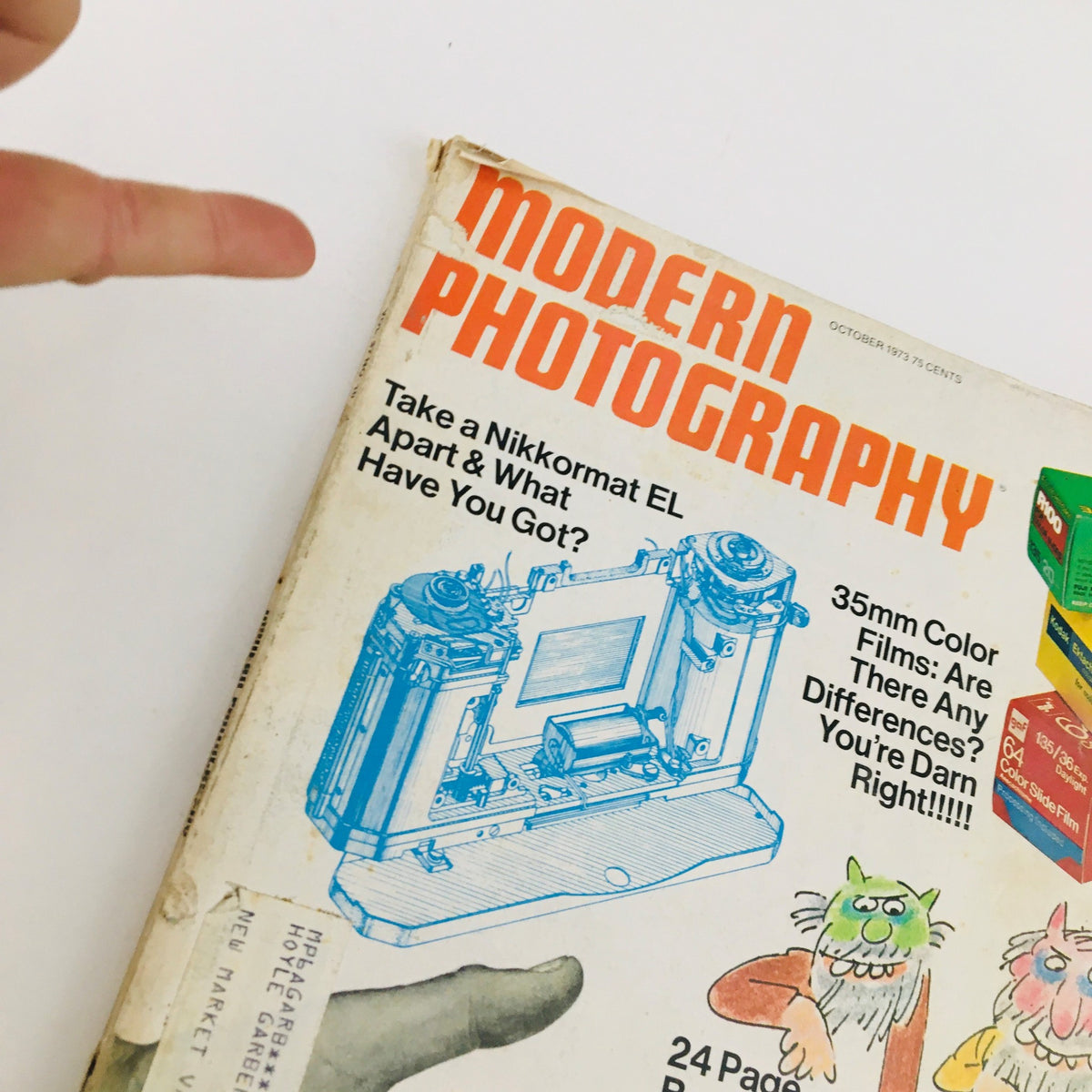 Close-up of the cover of Modern Photography Magazine, October 1973, highlighting the title and features including insights on camera mechanics.