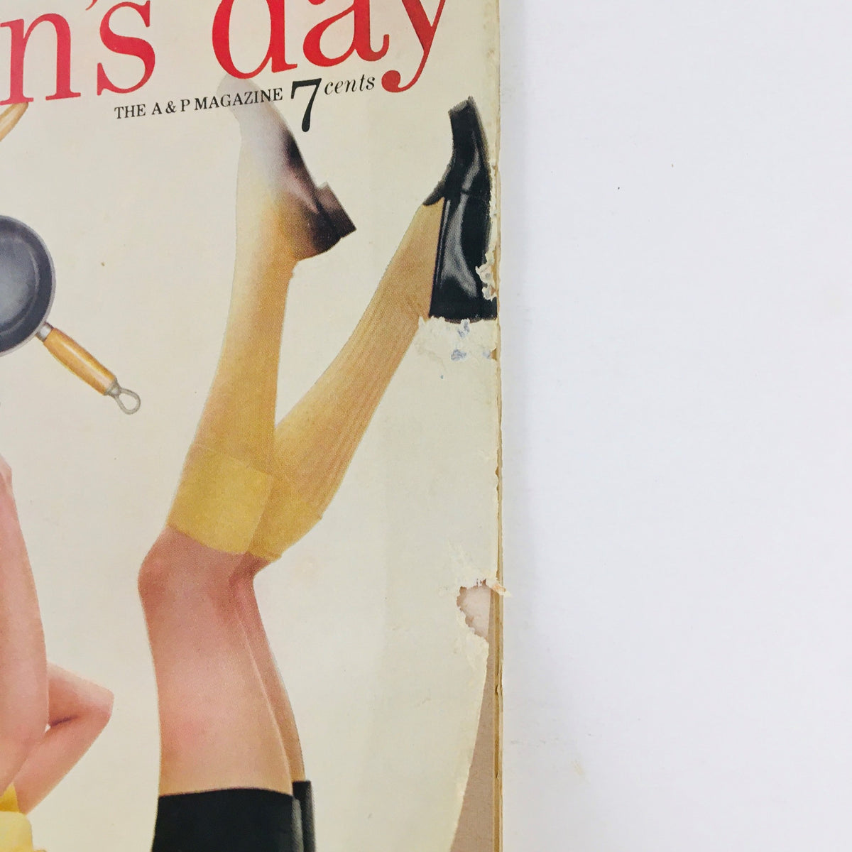 Side view of Woman's Day Magazine July 1954 cover with emphasis on the playful illustration of a woman and kitchen items, emphasizing the magazine's focus on summer cooking.