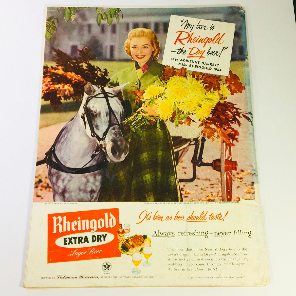 Cover of VTG Gourmet The Magazine of Good Living October 1954 featuring a vintage advertisement for Rheingold Extra Dry Beer, showcasing a woman in fashionable attire holding flowers and riding a horse.