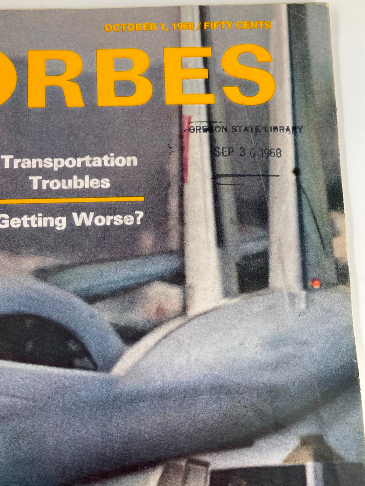 Detail of the top section of the cover of the VTG Forbes Magazine October 1, 1968, showing the title and library stamp with a date.