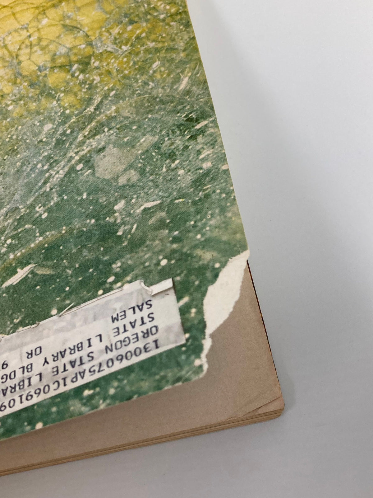 Detail view of the spine of the vintage Forbes Magazine from April 15, 1969, featuring wear and a library tag, promoting the issue on Procter & Gamble.