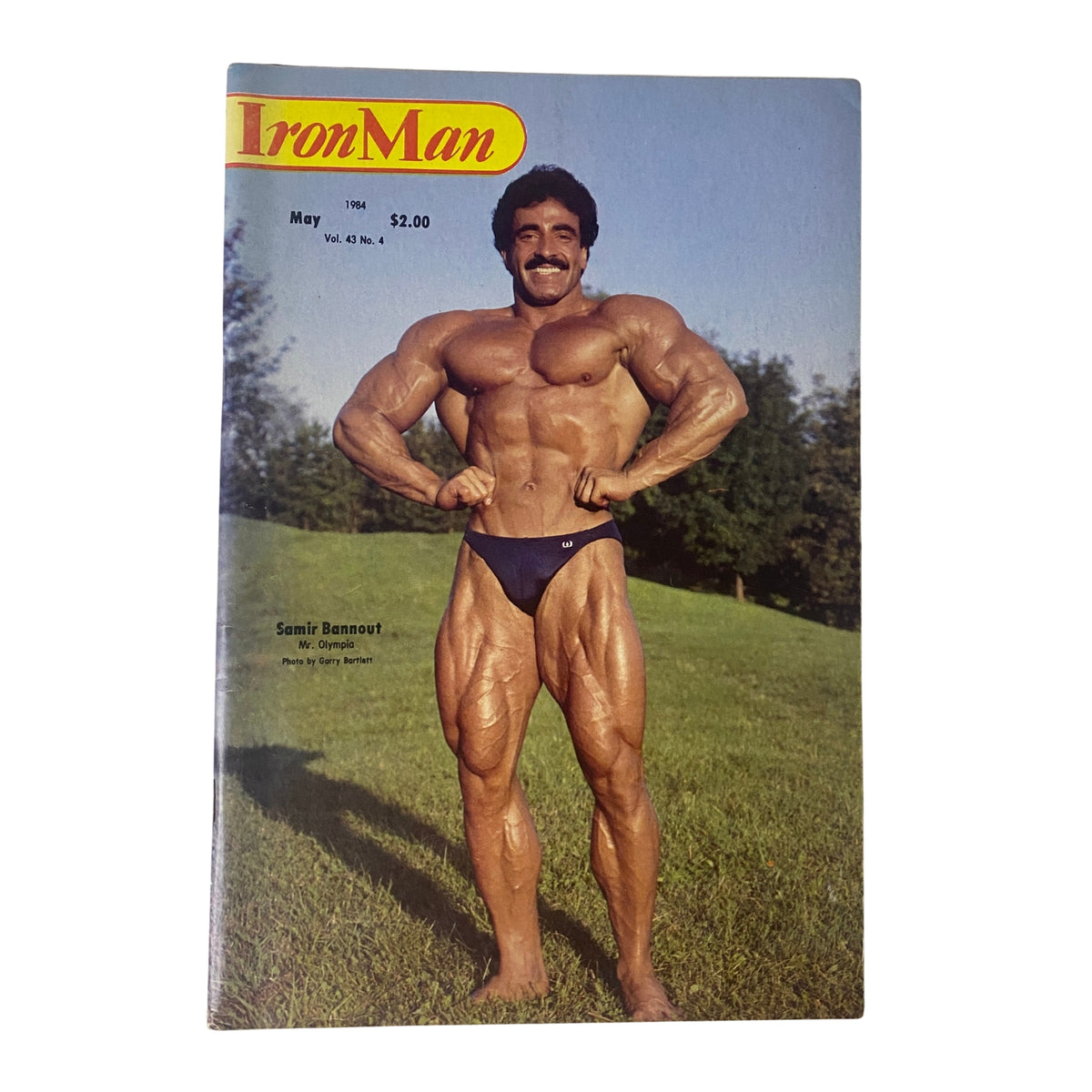IronMan Magazine May 1984 Vol 43 No. 4 featuring bodybuilder Samir Bannout on the cover, showcasing his muscular physique outdoors.