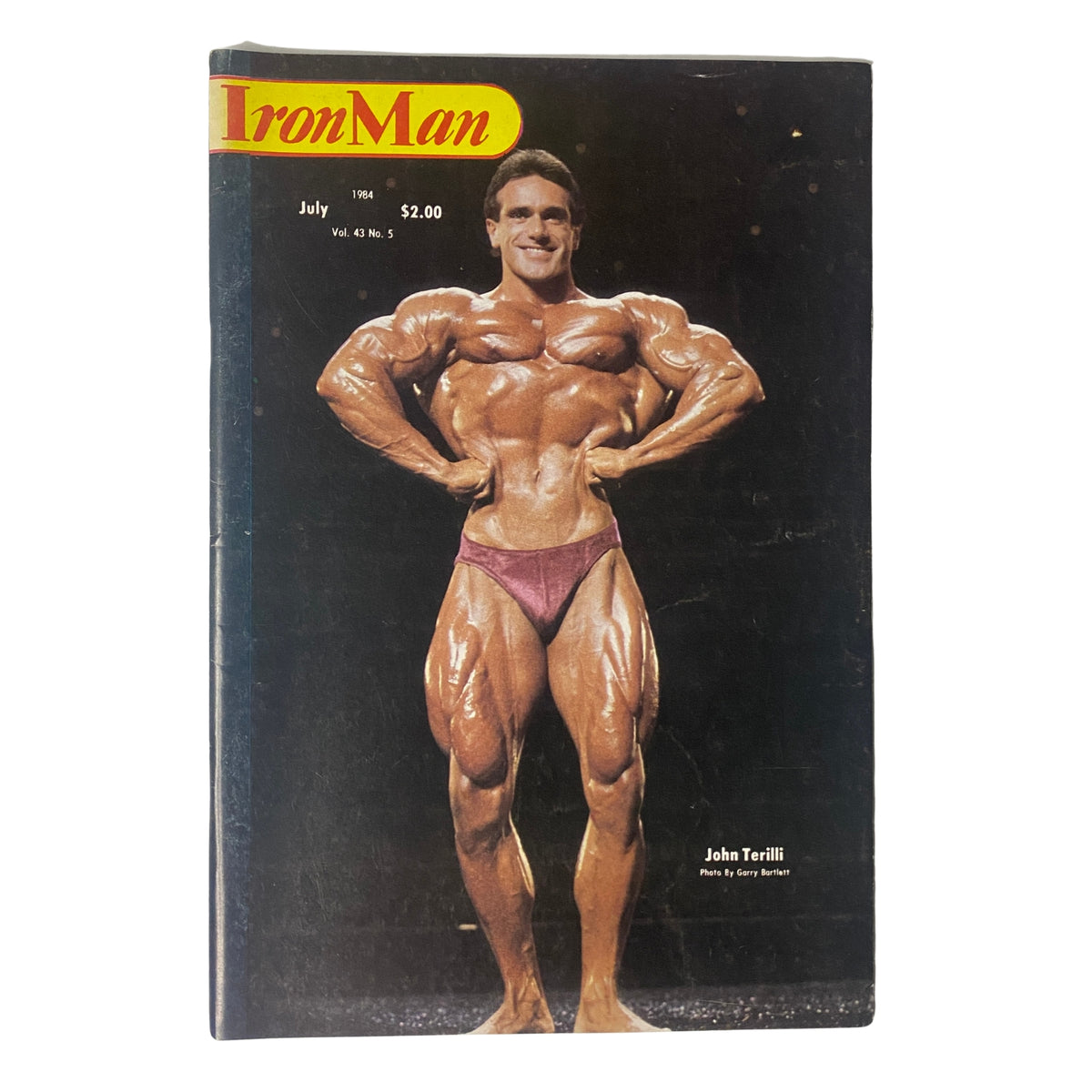 Cover of IronMan Magazine July 1984 featuring John Terilli, a renowned Australian bodybuilder, showcasing his impressive physique, in good condition, Volume 43, Number 5.