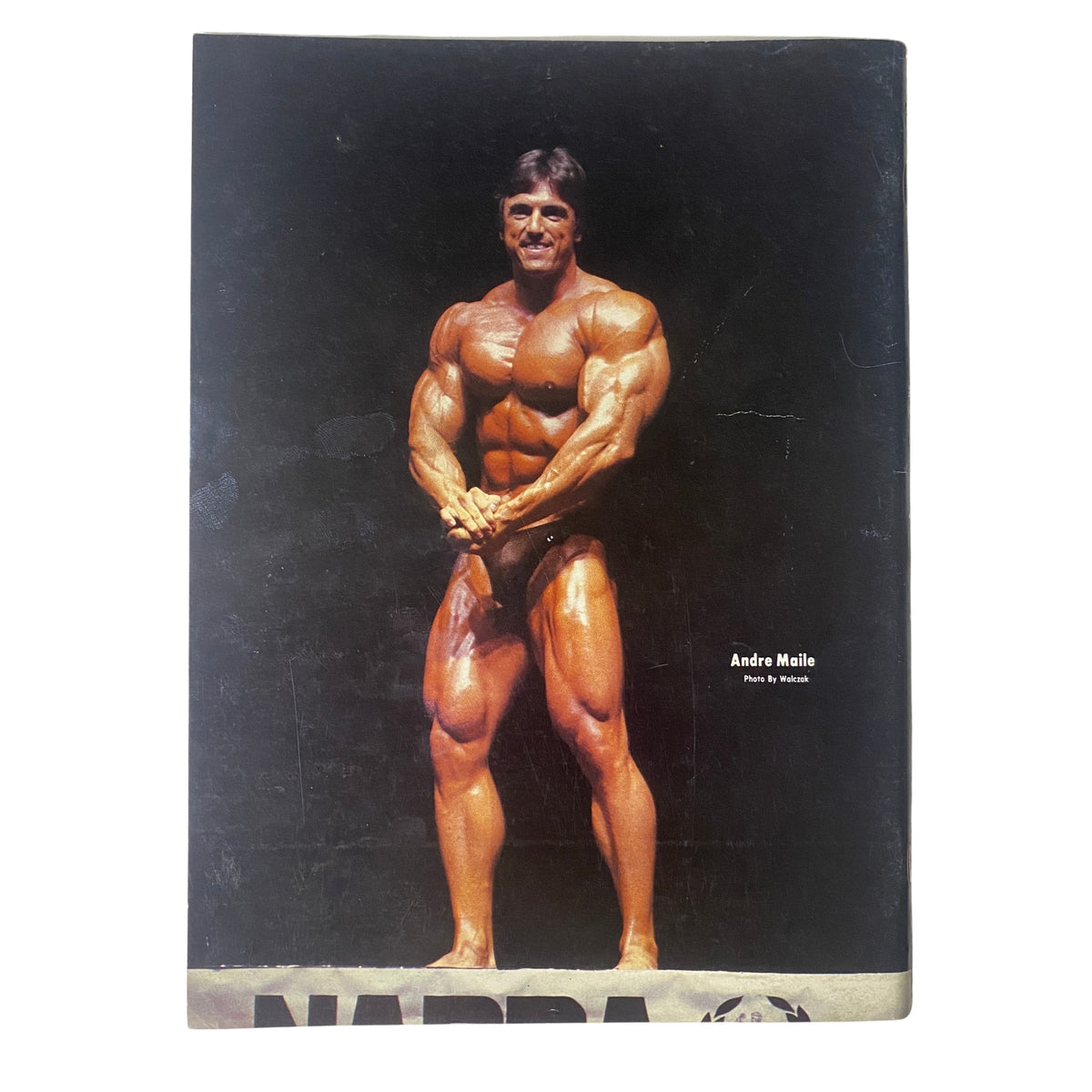 Back cover of IronMan Magazine March 1986 featuring André Malle, a bodybuilder, posing dramatically in a professional setting.