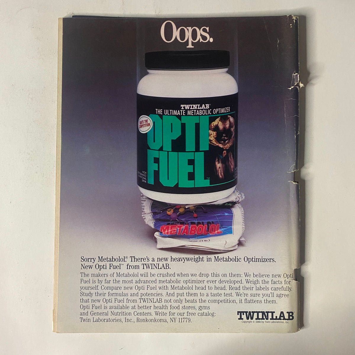 Back cover of IronMan Magazine, December 1988, Vol. 47 No. 12, showcasing an advertisement for TwinLab's Opti-Fuel, emphasizing its status as a new heavyweight in metabolic optimizers.