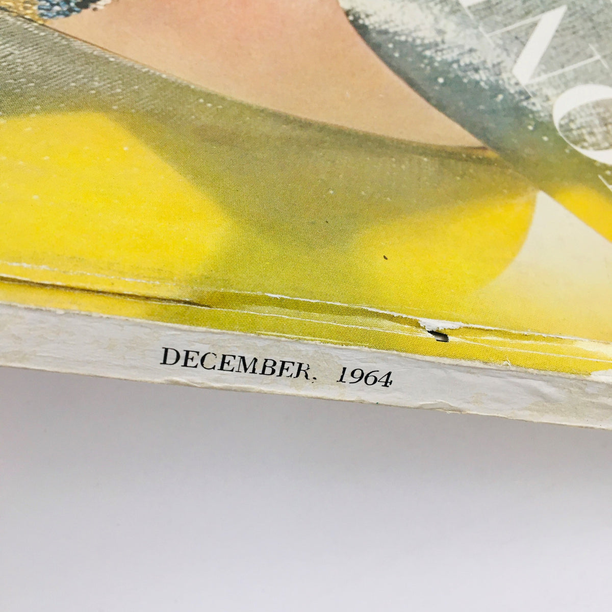 Detailed view of the spine of VTG Vogue Magazine December 1964, noting the publication date for collectors of vintage fashion magazines.