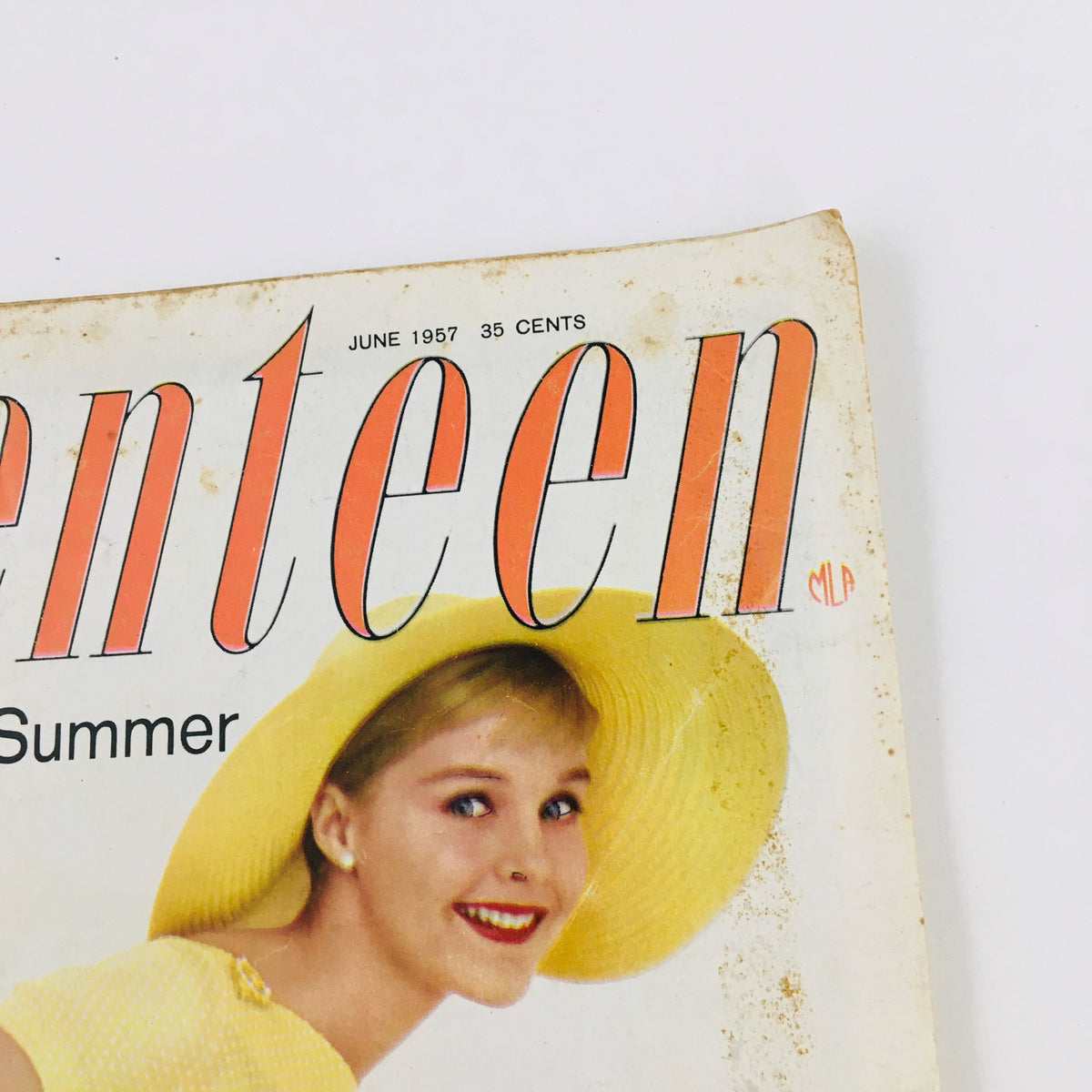 Detailed view of the VTG Seventeen Magazine June 1957 cover, showcasing a young woman wearing a yellow hat and smiling, with the magazine's date and price clearly visible.