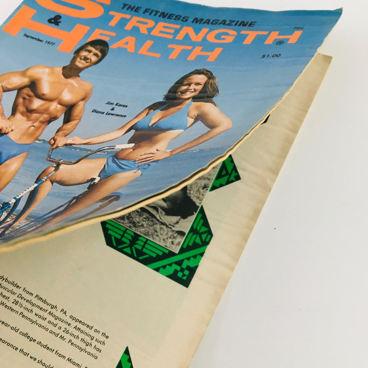 Close-up view of the Strength & Health Magazine September 1977 cover showing Jim Karas and Diana Lawrence with minor wear visible.
