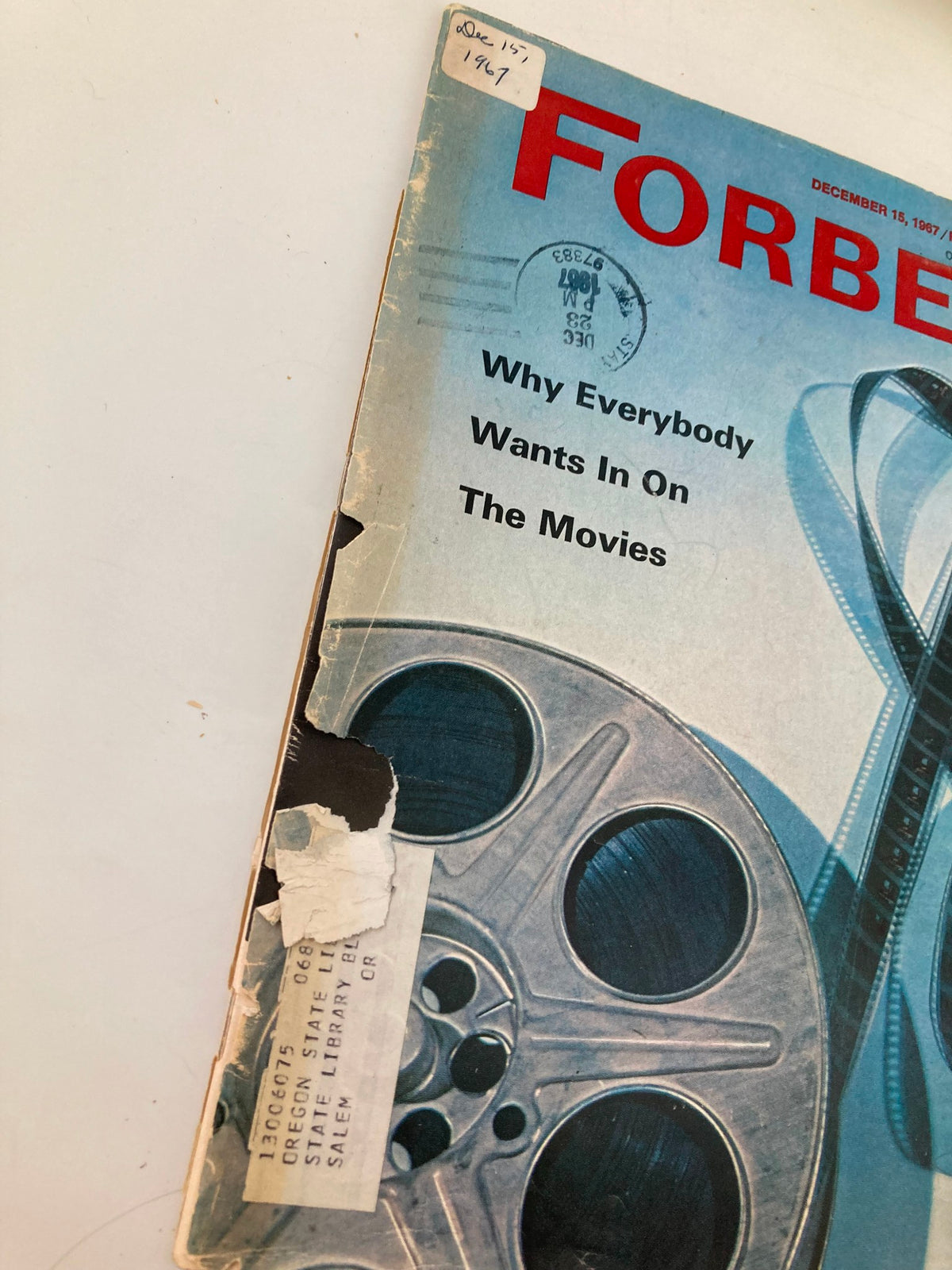 Detailed view of the cover of VTG Forbes Magazine December 15, 1967, showcasing the article 'Why Everybody Wants In On The Movies' and a library label.