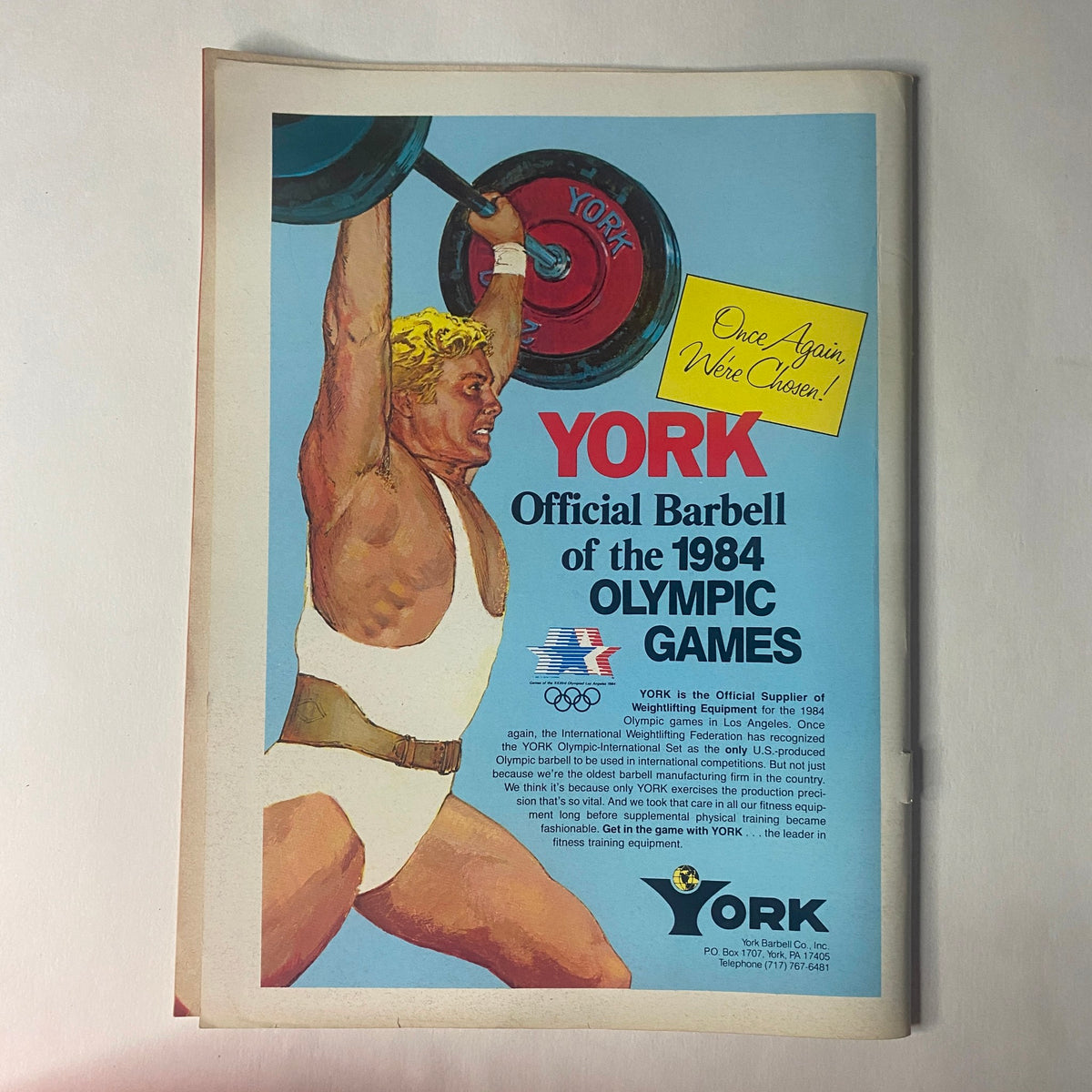 An advertisement page from Strength & Health Magazine January 1984 showcasing the YORK Official Barbell of the 1984 Olympic Games, featuring an illustration of an athlete lifting weights.