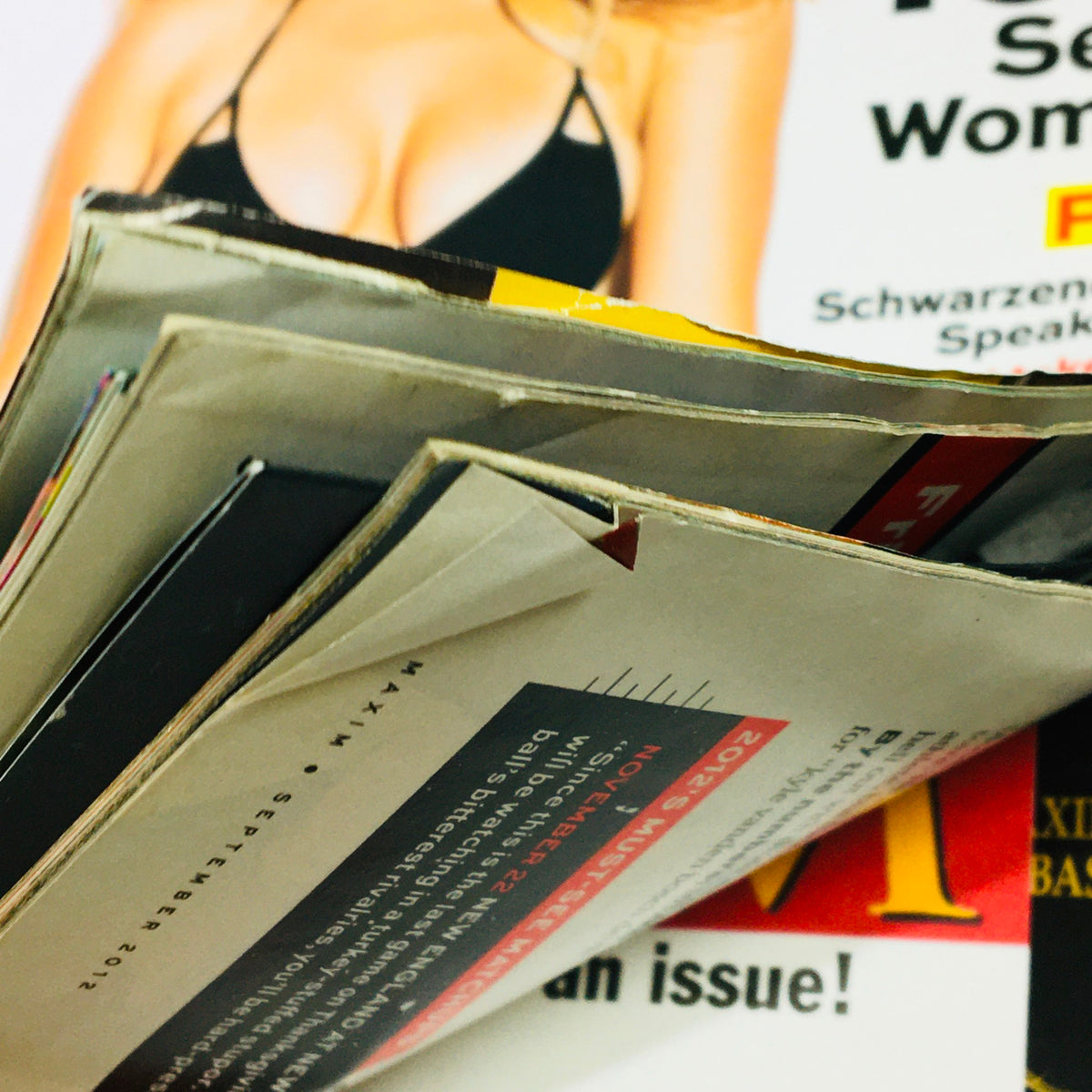 Close-up of the spine of Maxim Magazine September 2012, showing minor wear and tear, highlighting its collectible nature.