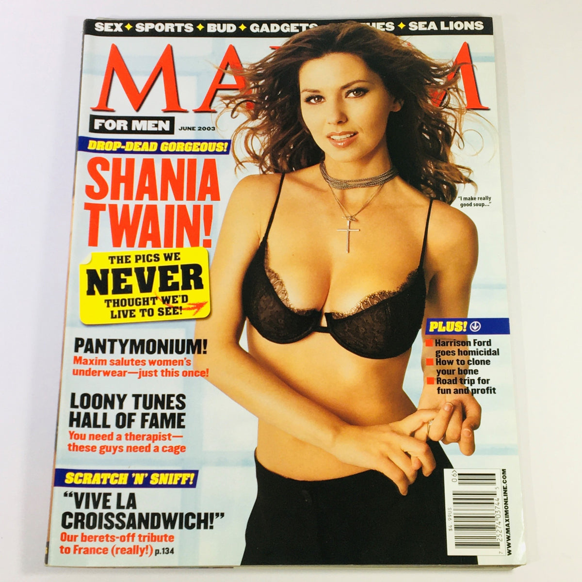 Maxim Magazine June 2003 featuring Shania Twain on the cover, showcasing a photo of her in a black bra, highlighting the magazine's bold and eye-catching design. This issue also includes Harrison Ford and various exciting features.