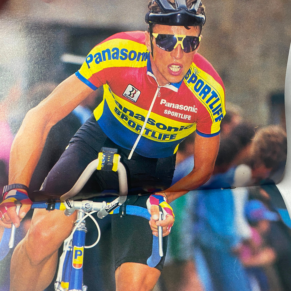 Action shot of Djamolidine Abdoujaparov during a race, wearing a colorful Team Panasonic jersey, from Winning Bicycle Racing Illustrated, March 1992.