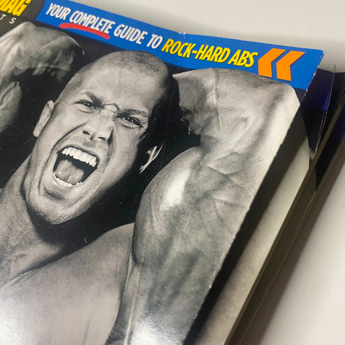 Close-up view of the cover of MuscleMag Magazine Summer 2011 Abs Special, emphasizing the tagline 'Your Complete Guide to Rock-Hard Abs' alongside an intense muscular model.