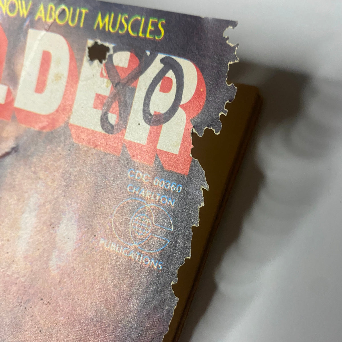 Close-up of the torn edge of Bodybuilder Magazine May 1980, highlighting the wear and age of the publication, part of the collectible magazine's condition.