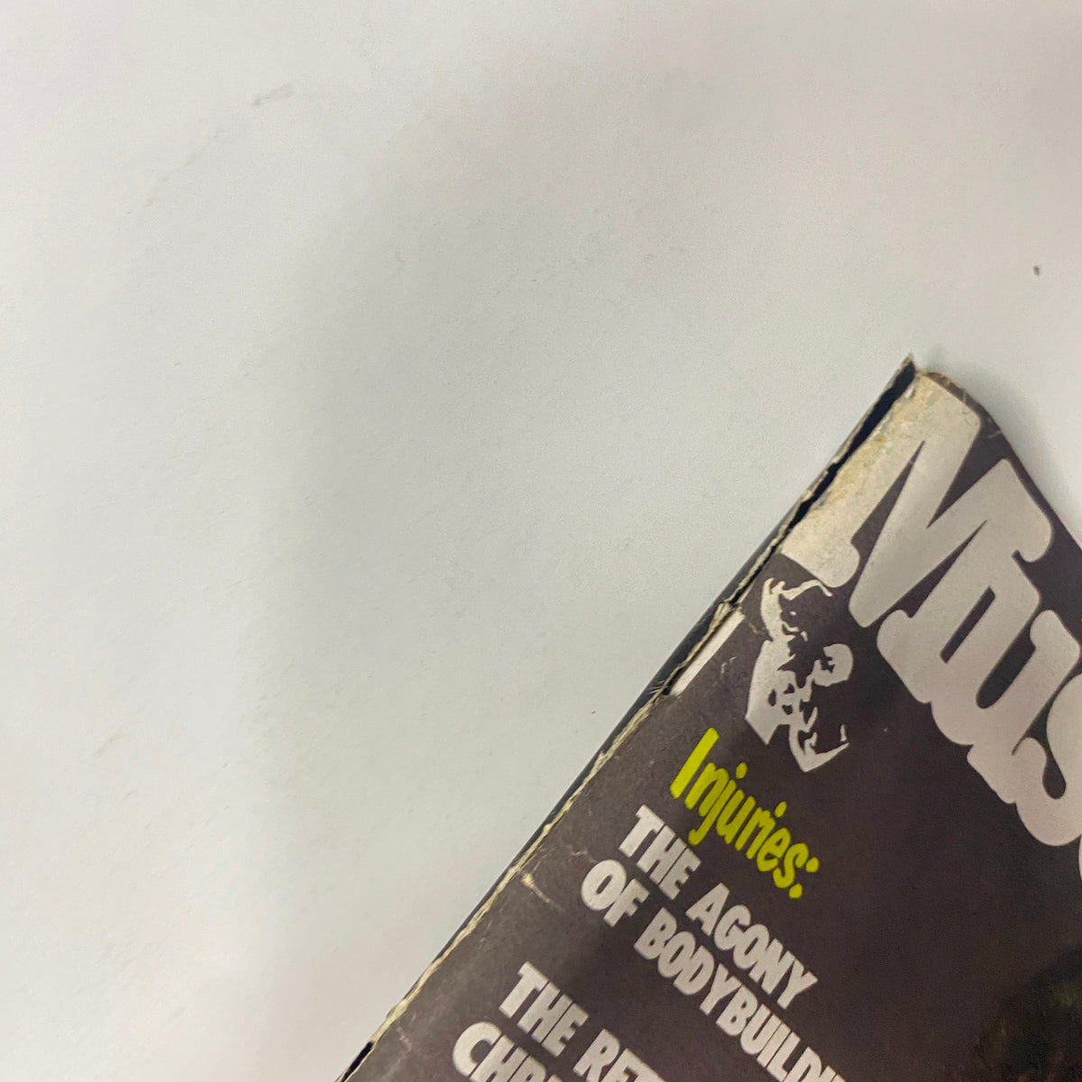 Close-up view of the top edge of Muscle Digest Magazine February 1980, showing light wear and condition details, highlighting the featured stories.