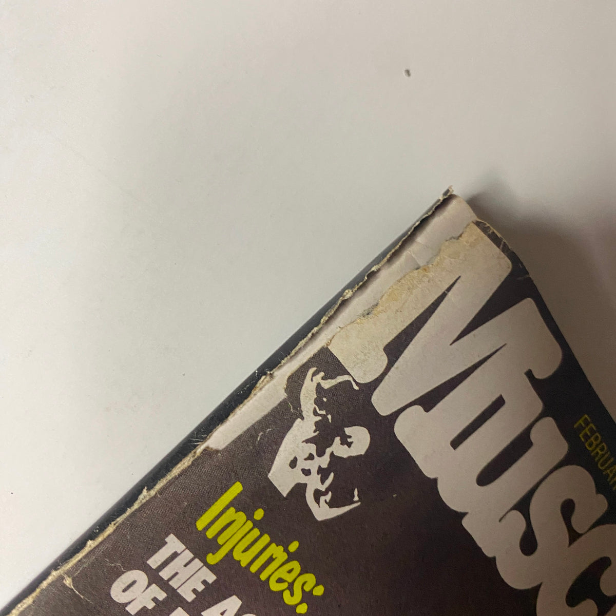 Close-up of the spine of Muscle Digest Magazine February 1980, displaying the magazine's title and slight wear on the edges, maintaining good condition.