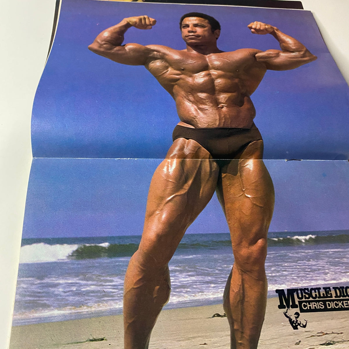 Centerfold from Muscle Digest Magazine February 1980 featuring Chris Dickerson showcasing his muscular physique at the beach, highlighting fitness and bodybuilding aesthetics.