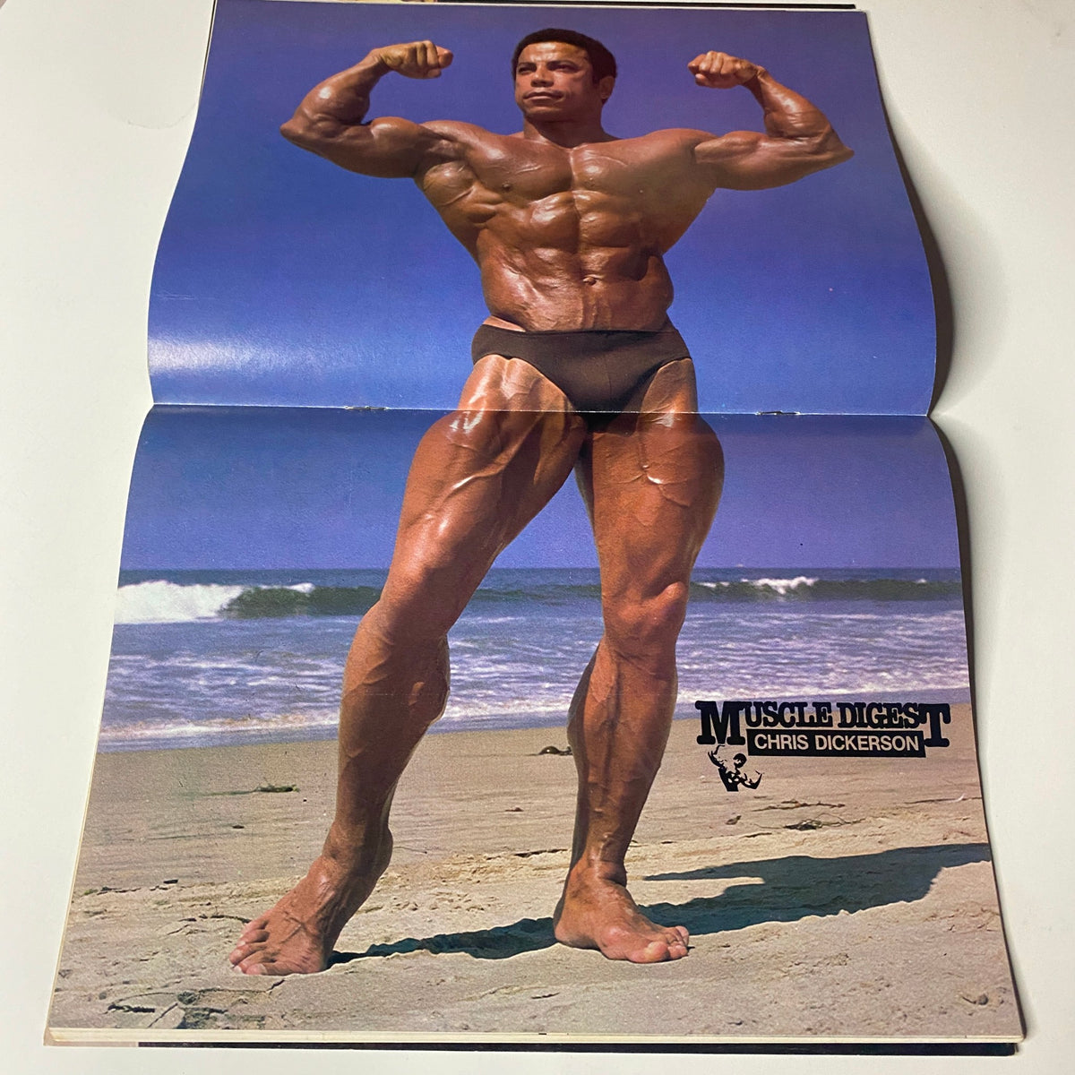 Centerfold of Muscle Digest Magazine February 1980 displaying Chris Dickerson posing on the beach, highlighting muscular physique and bodybuilding aesthetics.