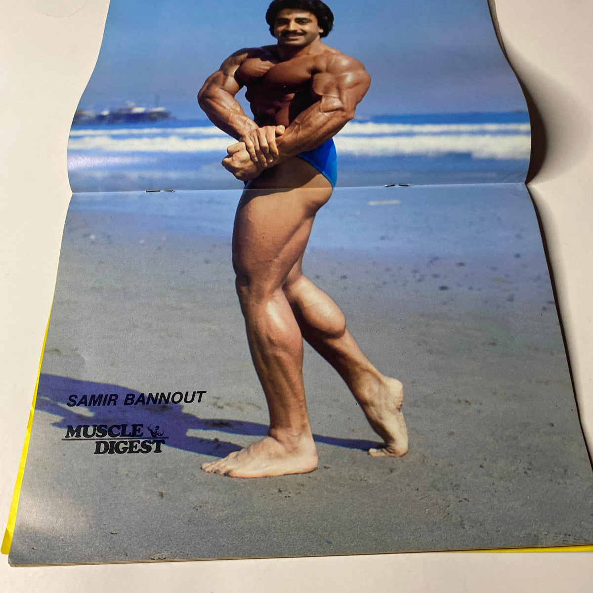 Muscle Digest Magazine April 1982 Vol 6 No 3 Centerfold image of bodybuilder Samir Bannout posing on the beach.