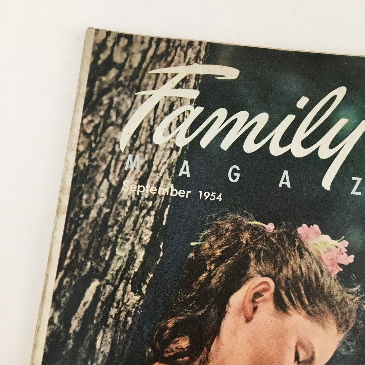 Family Circle Magazine September 1954 cover featuring a young girl with flowers in her hair and a wooden background.