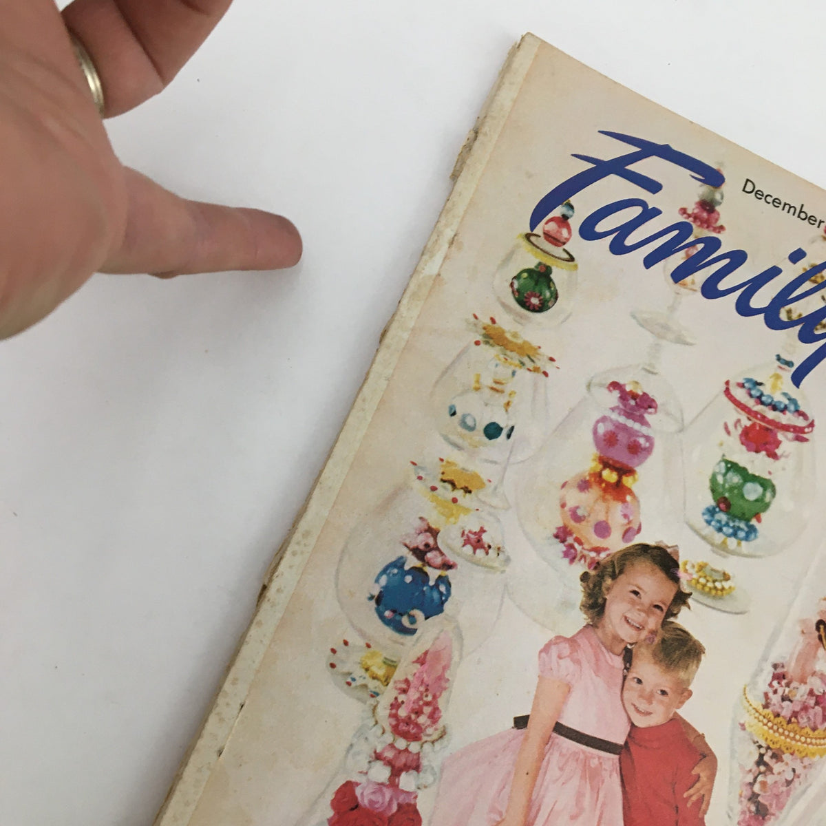 Cover of Family Circle Magazine December 1954 featuring two children with glass ornaments, highlighting 'The Most Beautiful Tree in the World' theme.