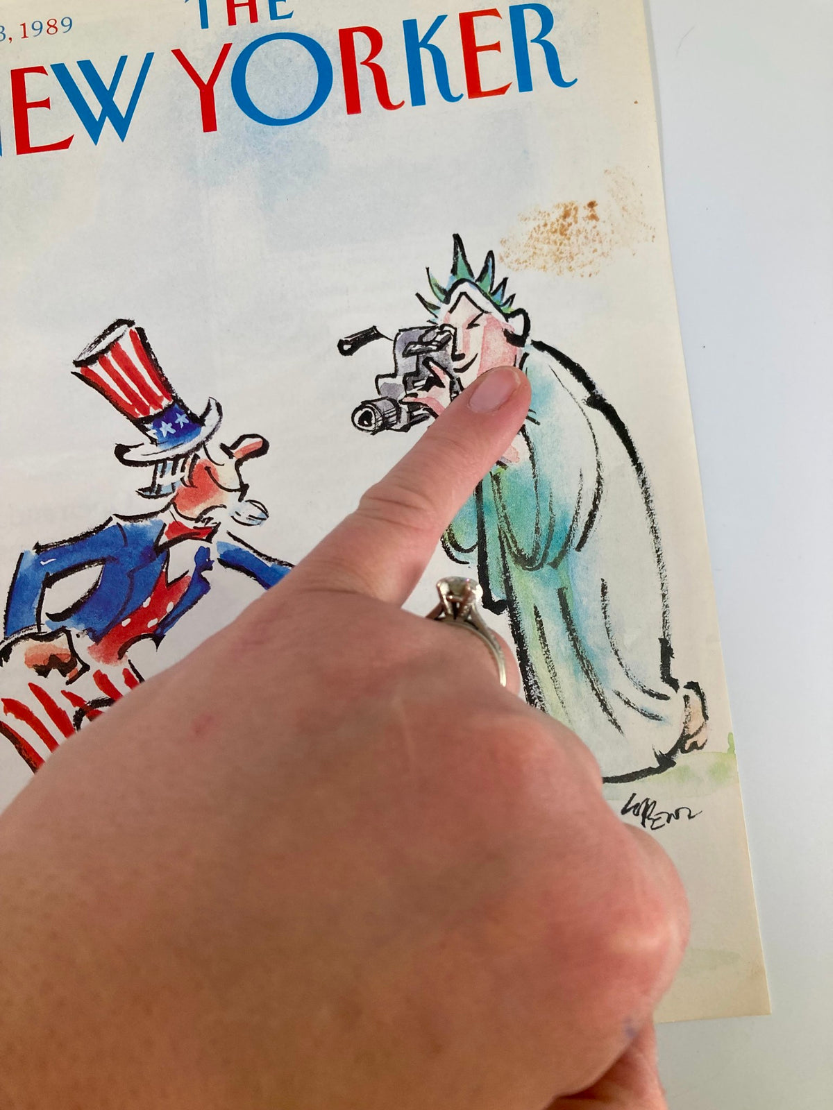 Close-up of The New Yorker cover from July 3, 1989, highlighting Uncle Sam and Lady Liberty, with details of the hand pointing to the illustration.