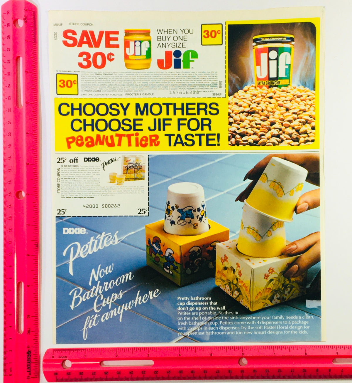 Close-up of vintage 1983 Jif Peanut Butter and Dixie Smurf Petites Bathroom Cups advertisement, displaying coupons and colorful cup dispensers emphasizing portability and design.