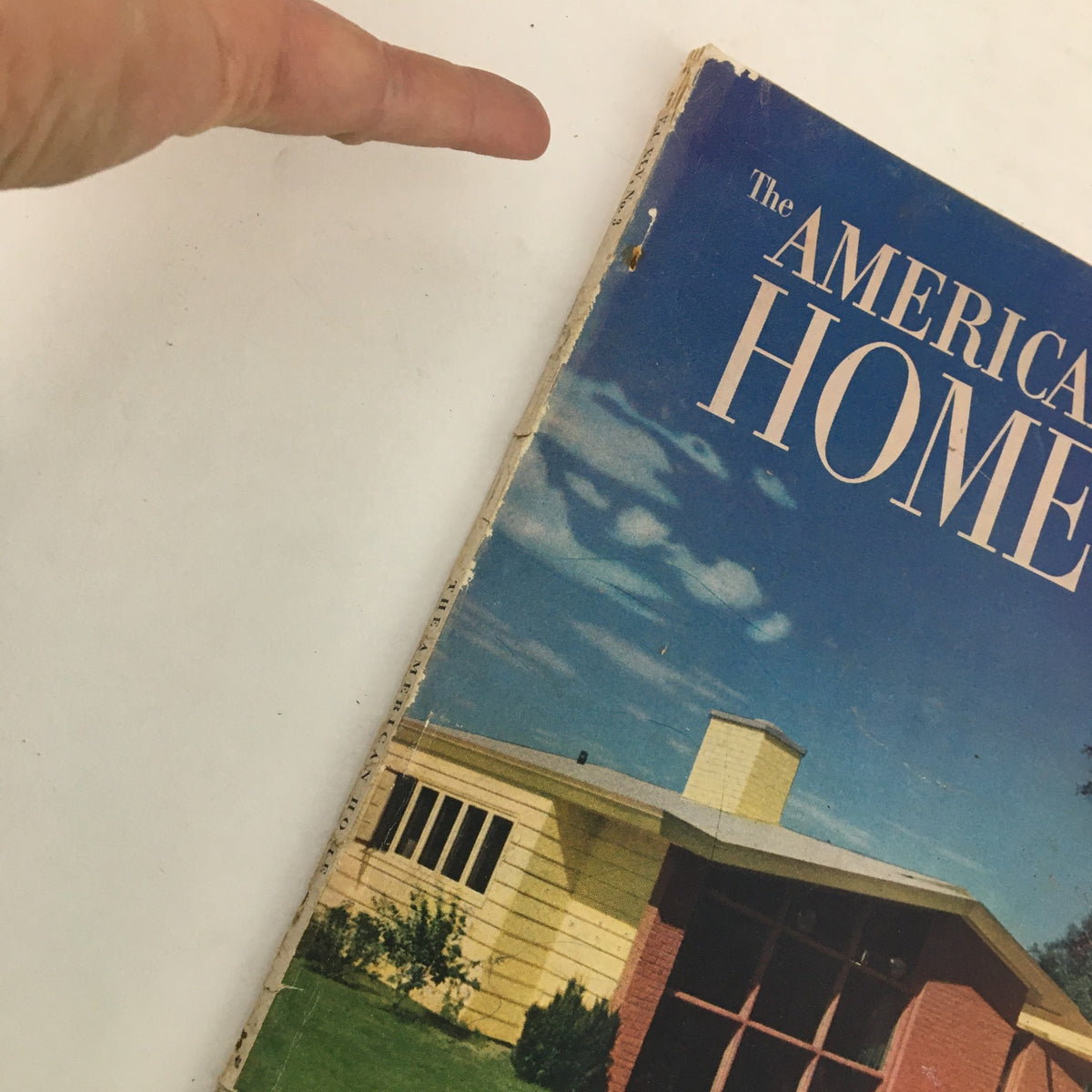 Side view of The American Home Magazine February 1951, highlighting the spine and cover details, illustrating its vintage condition.