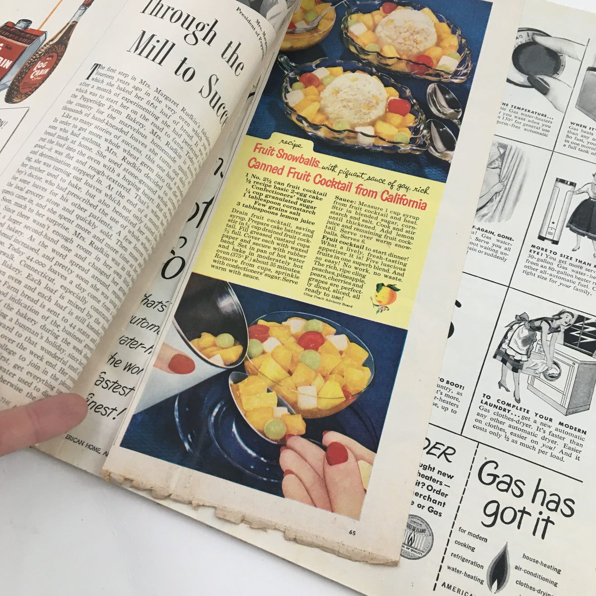Recipe page from The American Home Magazine April 1951 featuring 'Fruit Snowballs' and a colorful canned fruit cocktail presentation.