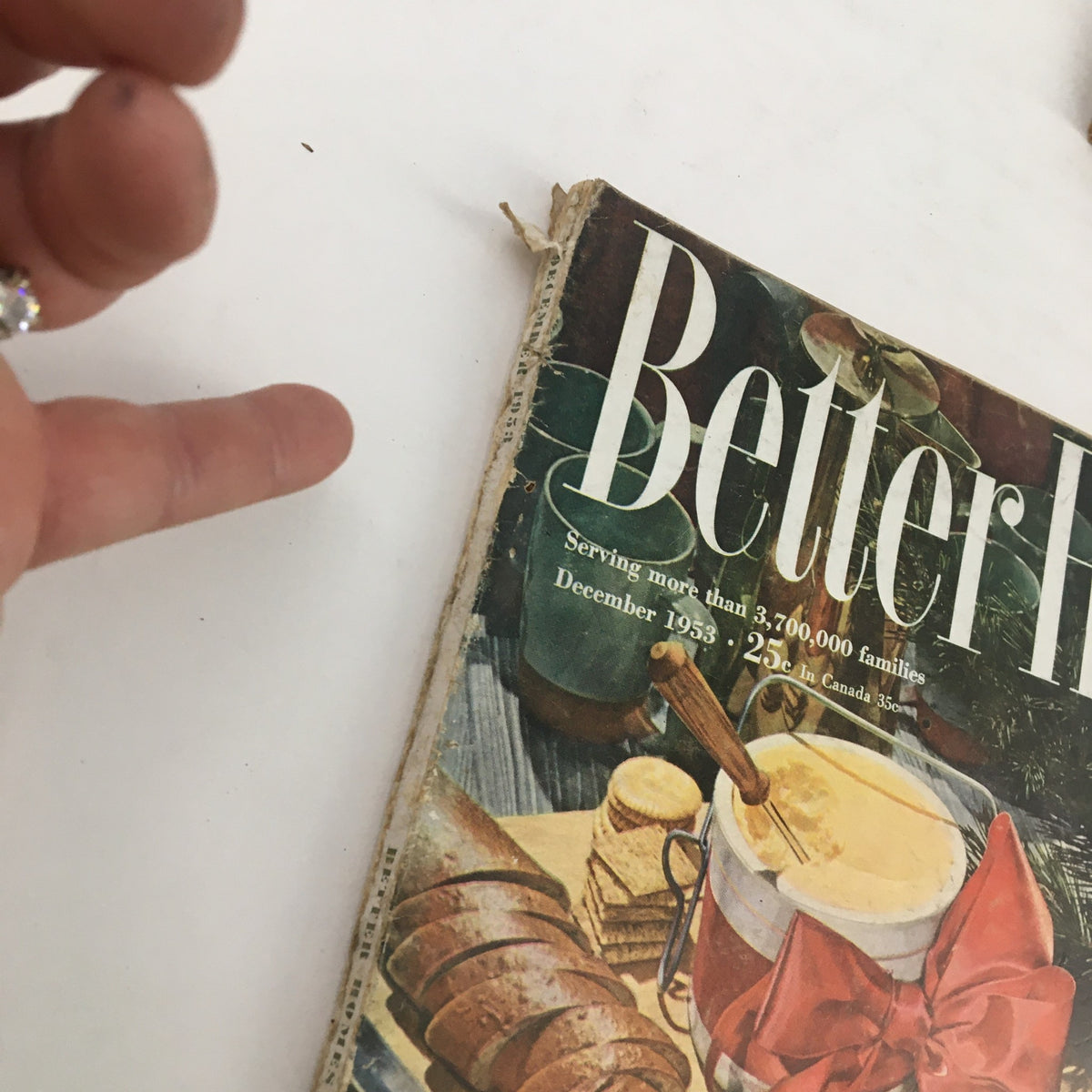 Close-up of the edge of Better Homes & Gardens December 1953 magazine cover, showcasing vintage details and wear, emphasizing its collectible nature.