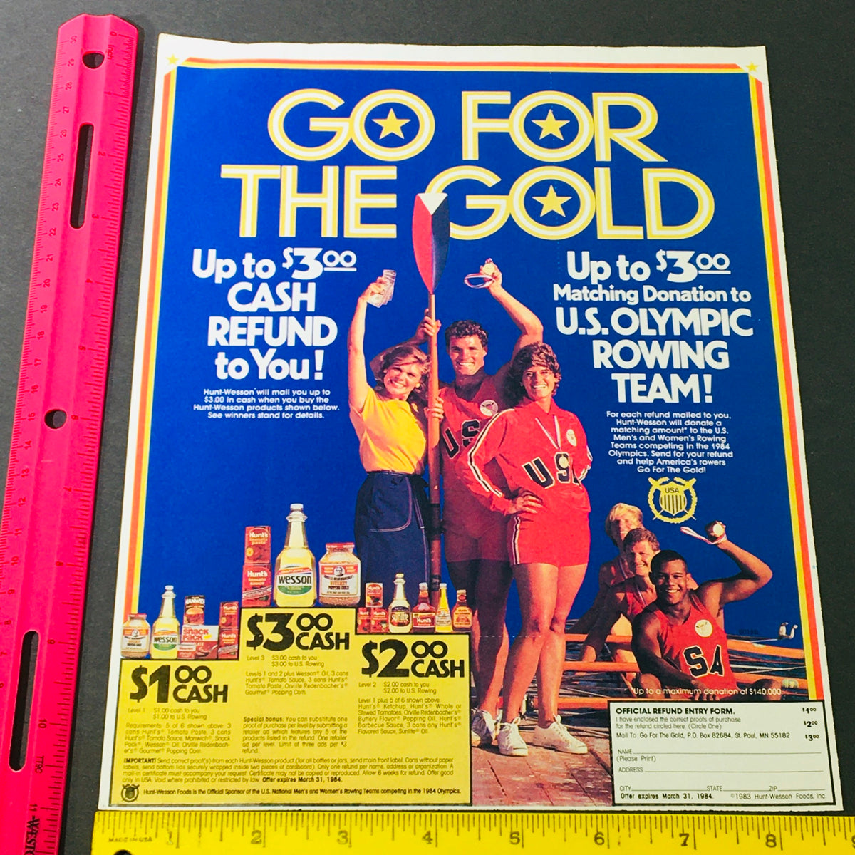 Image of a retro advertisement promoting cash refunds with the title 'GO FOR THE GOLD.' Highlights an offer for matching donations to the U.S. Olympic Rowing Team. Part of the VTG Retro 1984 Hunt-Wesson Foods U.S. Olympic Rowing Team Sponsor Ad Coupon collection.