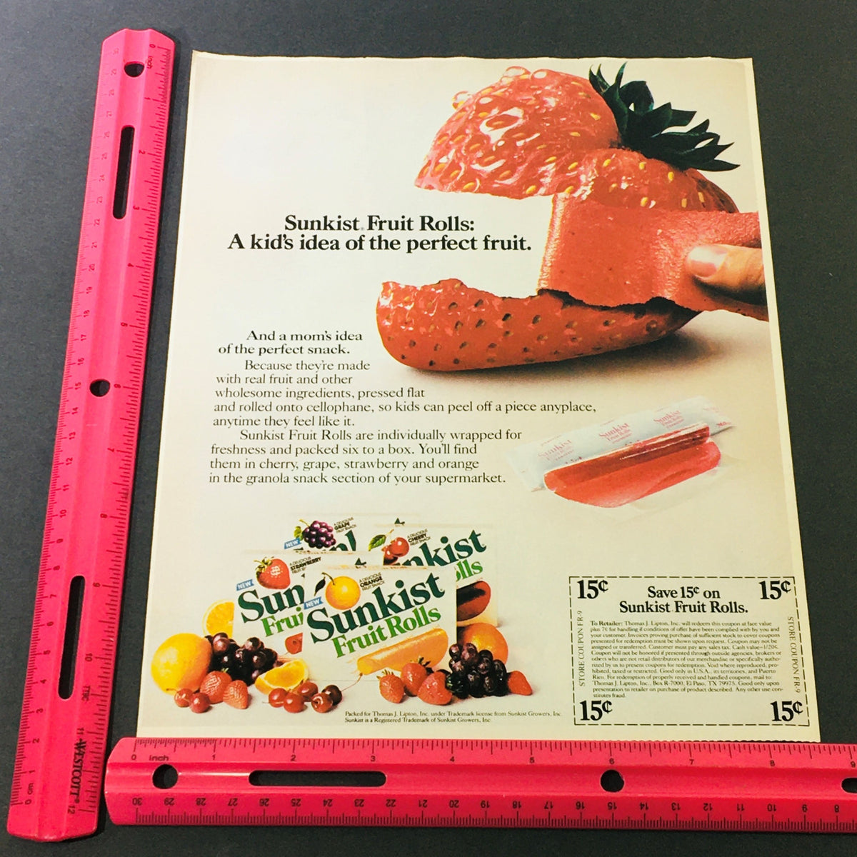 VTG Retro 1984 Sunkist Fruit Rolls Snack & Promise Toothpaste Discount Ad Coupon, showcasing a colorful advertisement featuring Sunkist Fruit Rolls, complete with vibrant fruit imagery and a child-friendly tagline, displayed alongside a ruler for size reference.