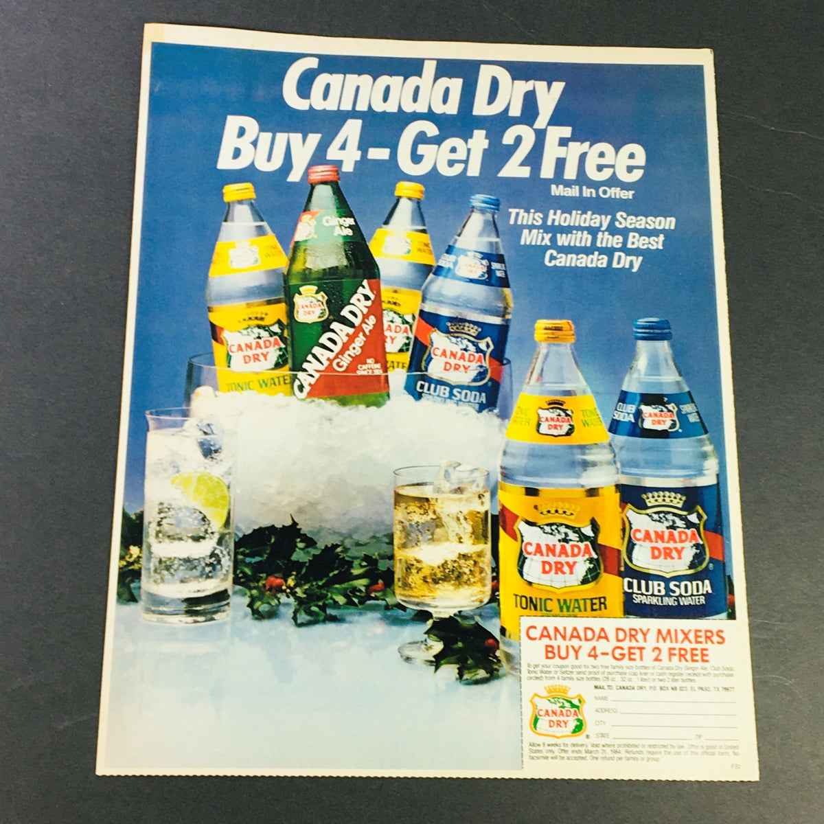 VTG Retro 1984 Canada Dry Tonic Water & Club Soba Sparkling Water advertisement featuring a colorful display of beverage bottles and a promotional 'Buy 4 - Get 2 Free' offer during the holiday season.