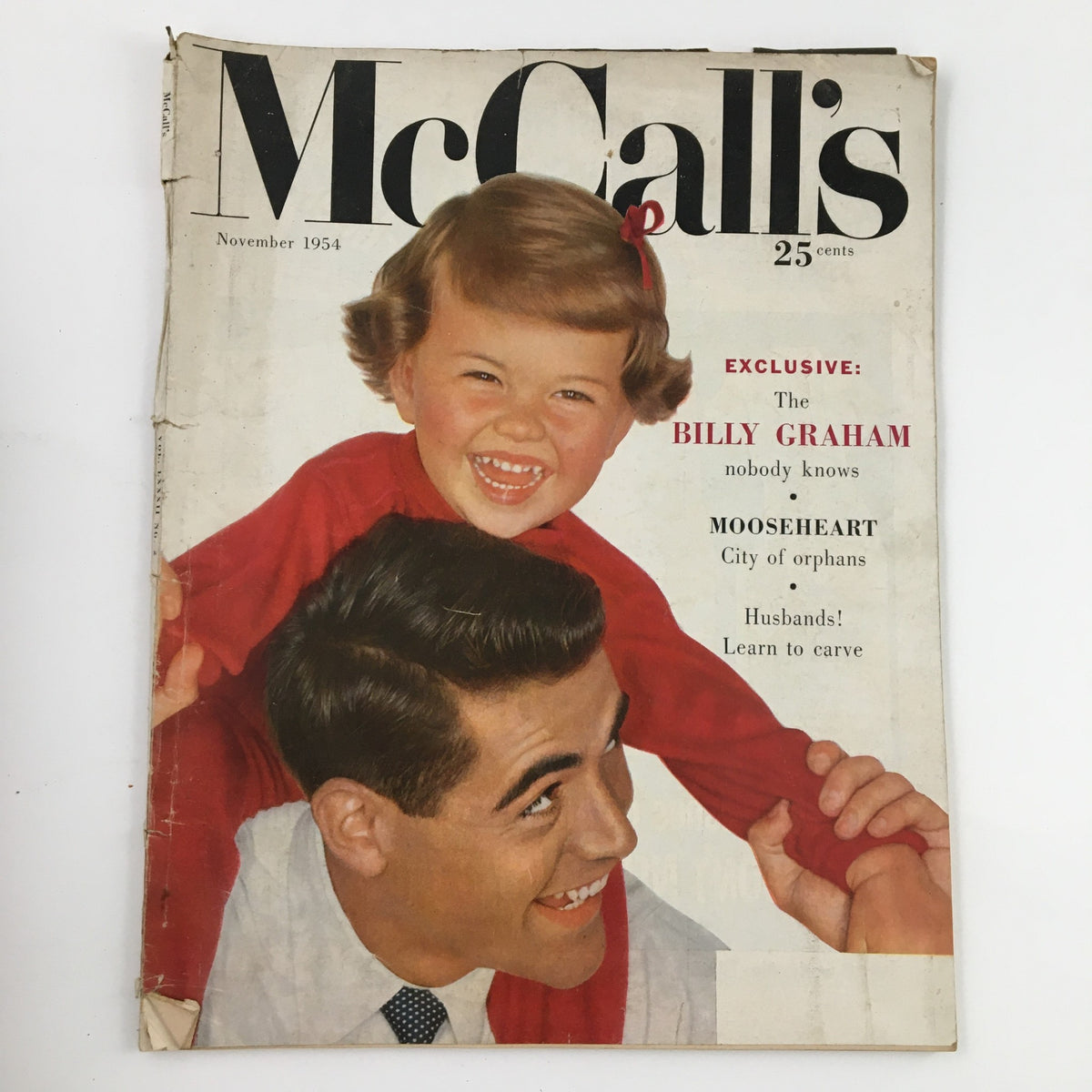 Cover of McCall's Magazine November 1954 featuring an exclusive article on 'The Billy Graham That Nobody Knows', showcasing a father and child in a joyful pose.
