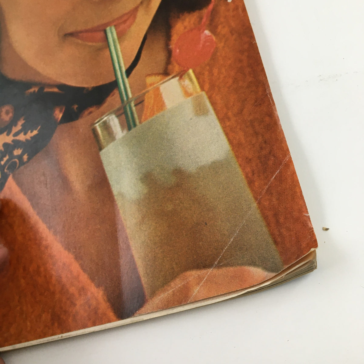 Detail of a woman sipping a drink from McCall's Magazine July 1969, showcasing 1960s fashion and nostalgia.