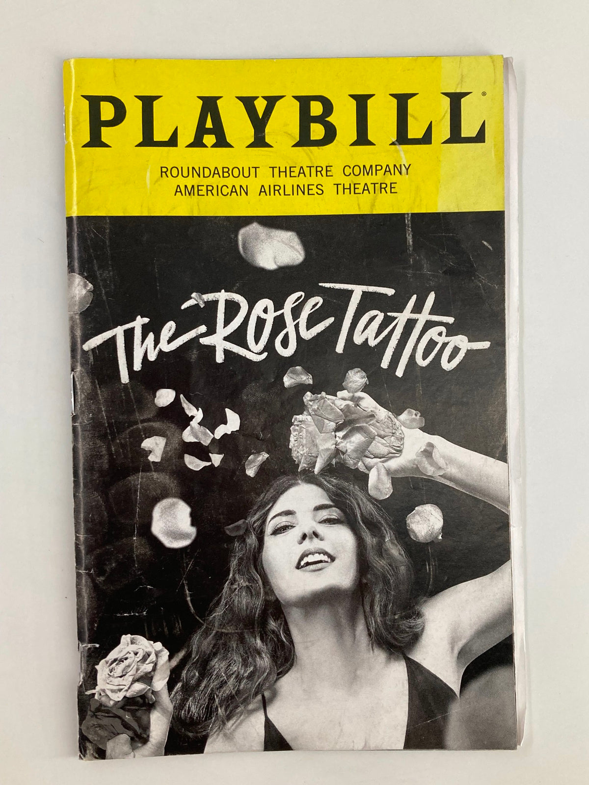 2019 Playbill for 'The Rose Tattoo' by Tennessee Williams, showcasing an artistic cover with a black and white image of an actress holding roses, from the American Airlines Theatre.