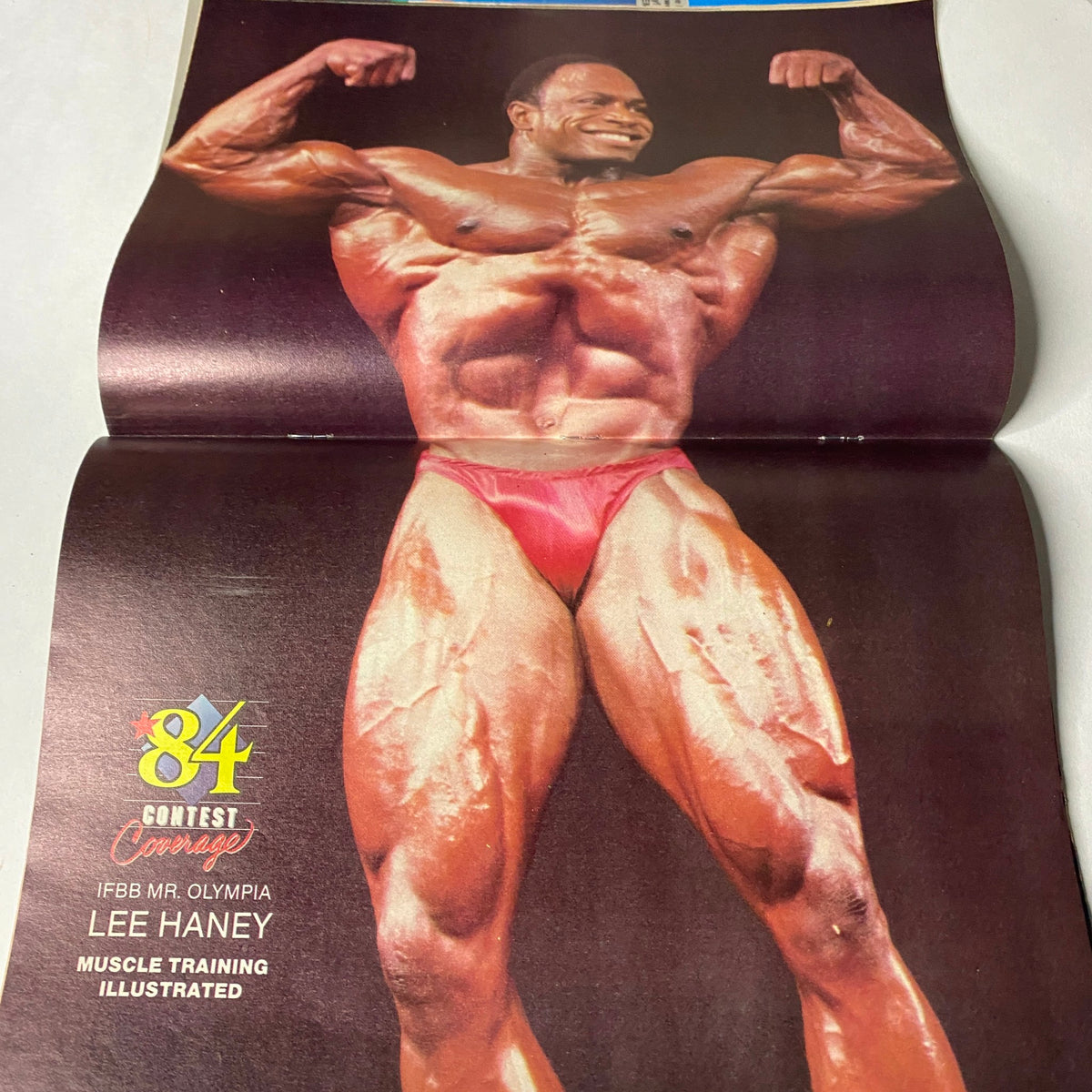 Lee Haney, Mr. Olympia featured in Muscle Training Illustrated, April 1985, No. 122, showcasing impressive physique and muscles.