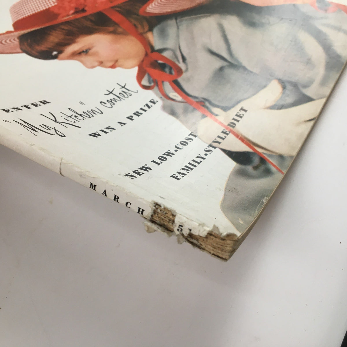 Close-up of the side edge of McCall's Magazine March 1951, revealing wear and the title details for March.