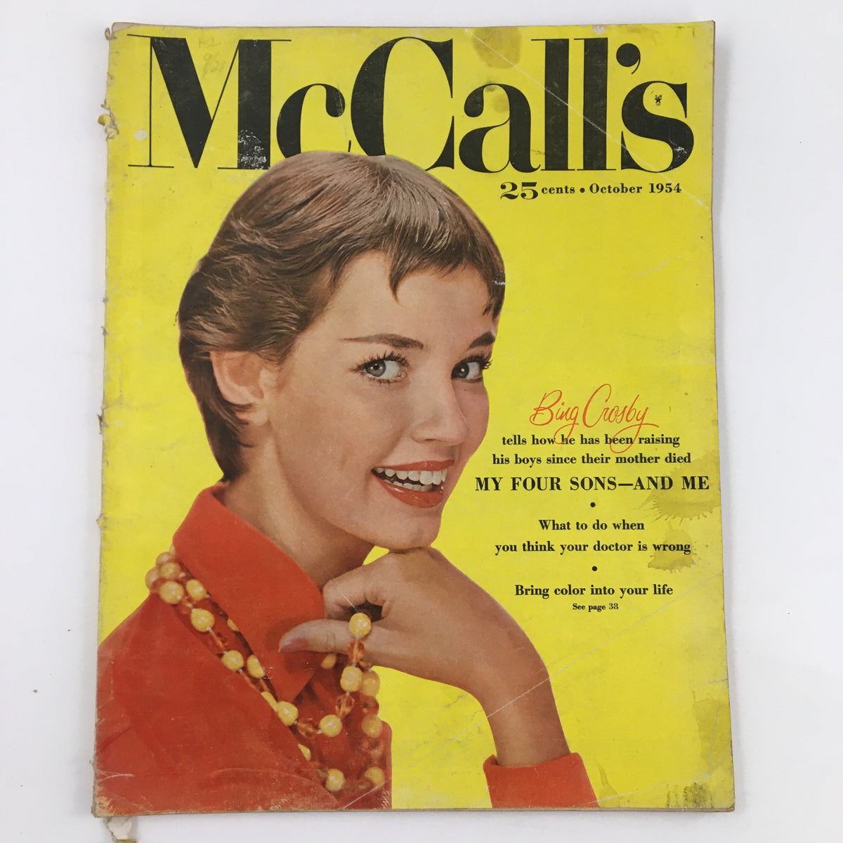 Cover of McCall's Magazine from October 1954 featuring a smiling woman in a red blouse with a pearl necklace, highlighting Bing Crosby in 'My Four Sons and Me.' Vintage publication showcasing the essence of the 1950s.