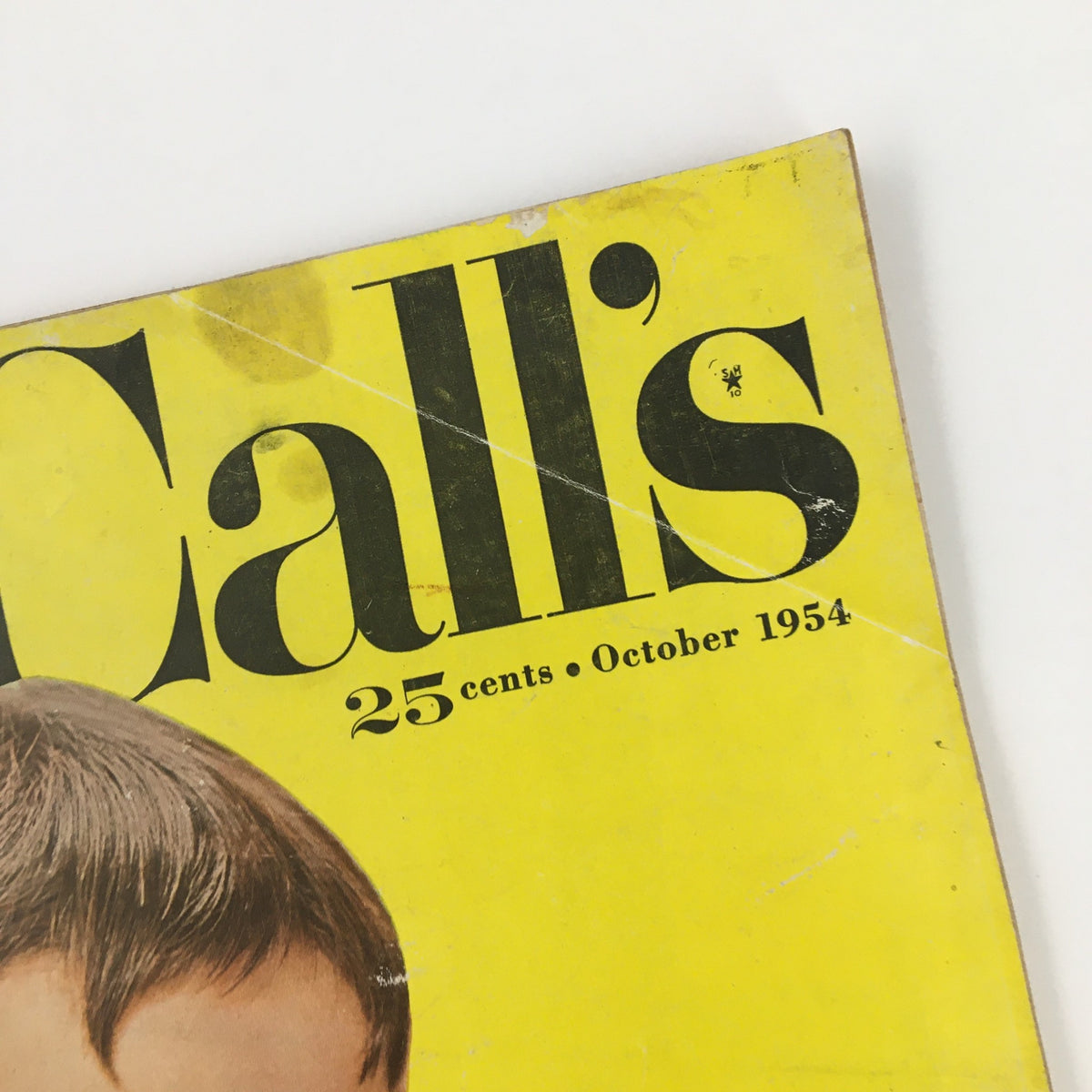 Image of the top right corner of McCall's Magazine, October 1954, exhibiting the date and magazine title with light damage.