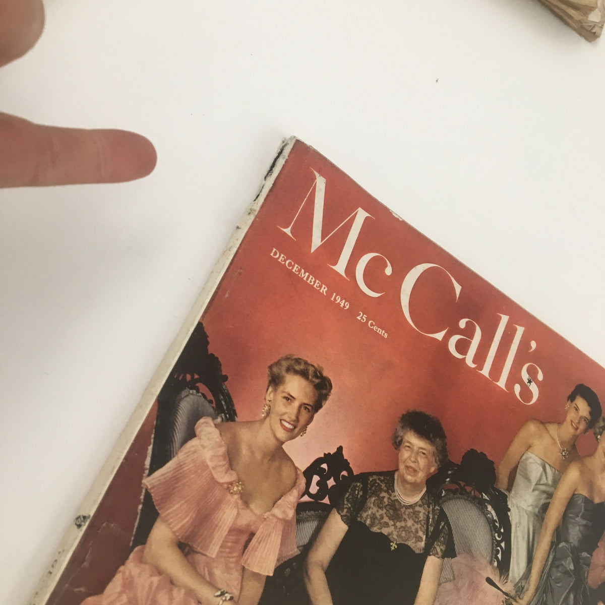 Close-up of the cover of McCall's Magazine December 1949 showing the title and a group of women in festive dresses.
