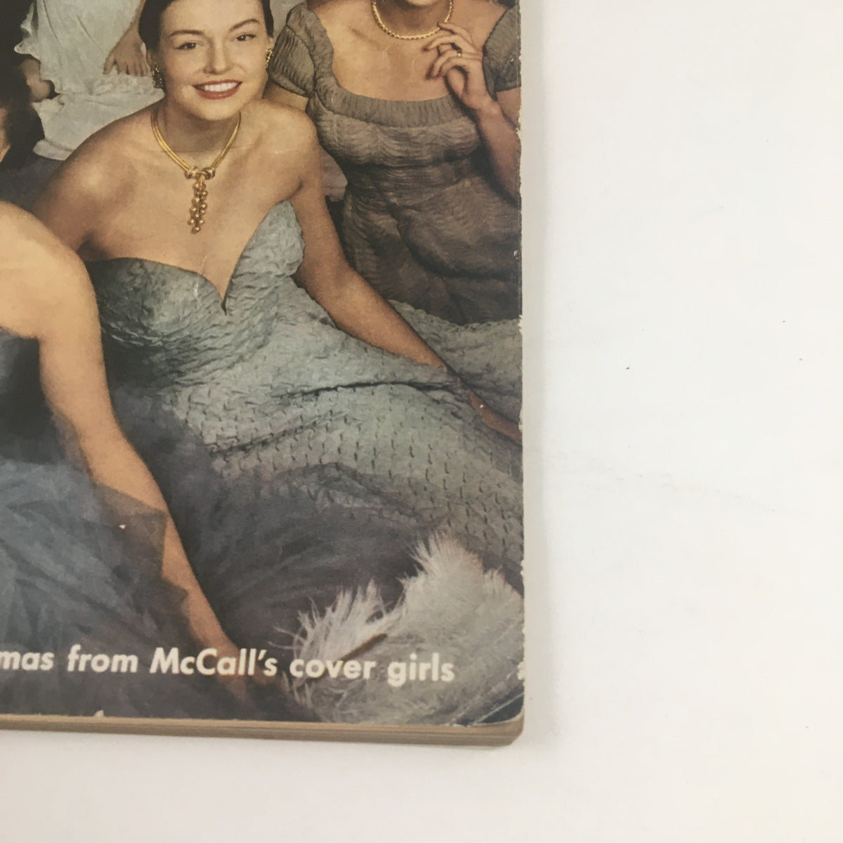 Detail of McCall's Magazine December 1949 cover showcasing women in glamorous gowns and jewelry, enhancing the vintage Christmas theme.