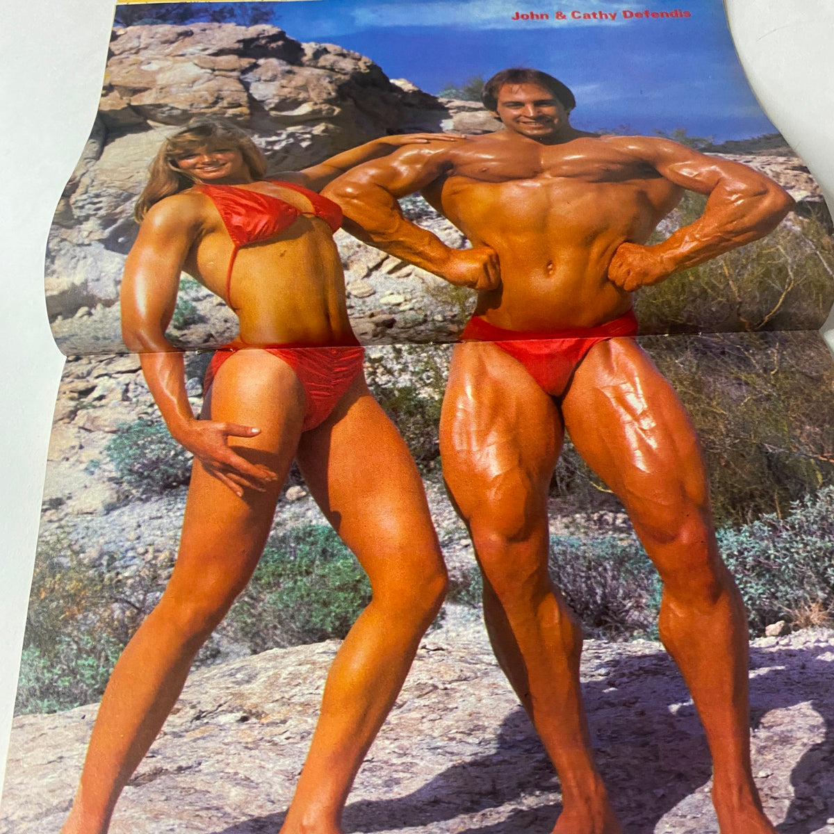 Centerfold from Fitness and Nutrition Magazine Winter 1984 showcasing bodybuilders John and Cathy DeFendis in vibrant red swimsuits, emphasizing the magazine's focus on fitness.